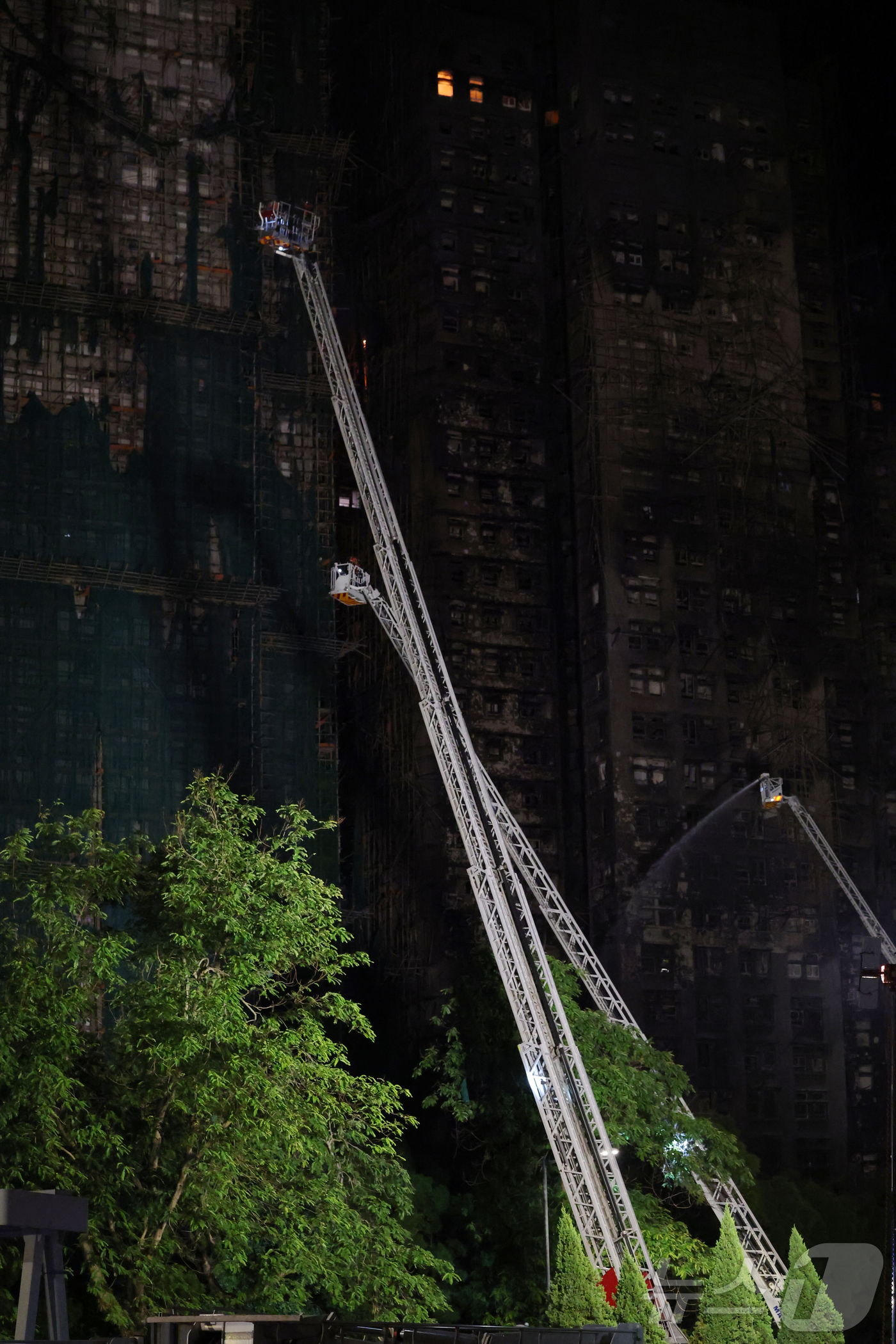 (홍콩=뉴스1) 권현진 기자 = 27일 홍콩 북부 타이포 구역의 아파트 단지 웡 푹 코트(Wang Fuk Court) 화재 현장에서 소방대원들이 잔불처리와 실종자 수색작업을 하고 …