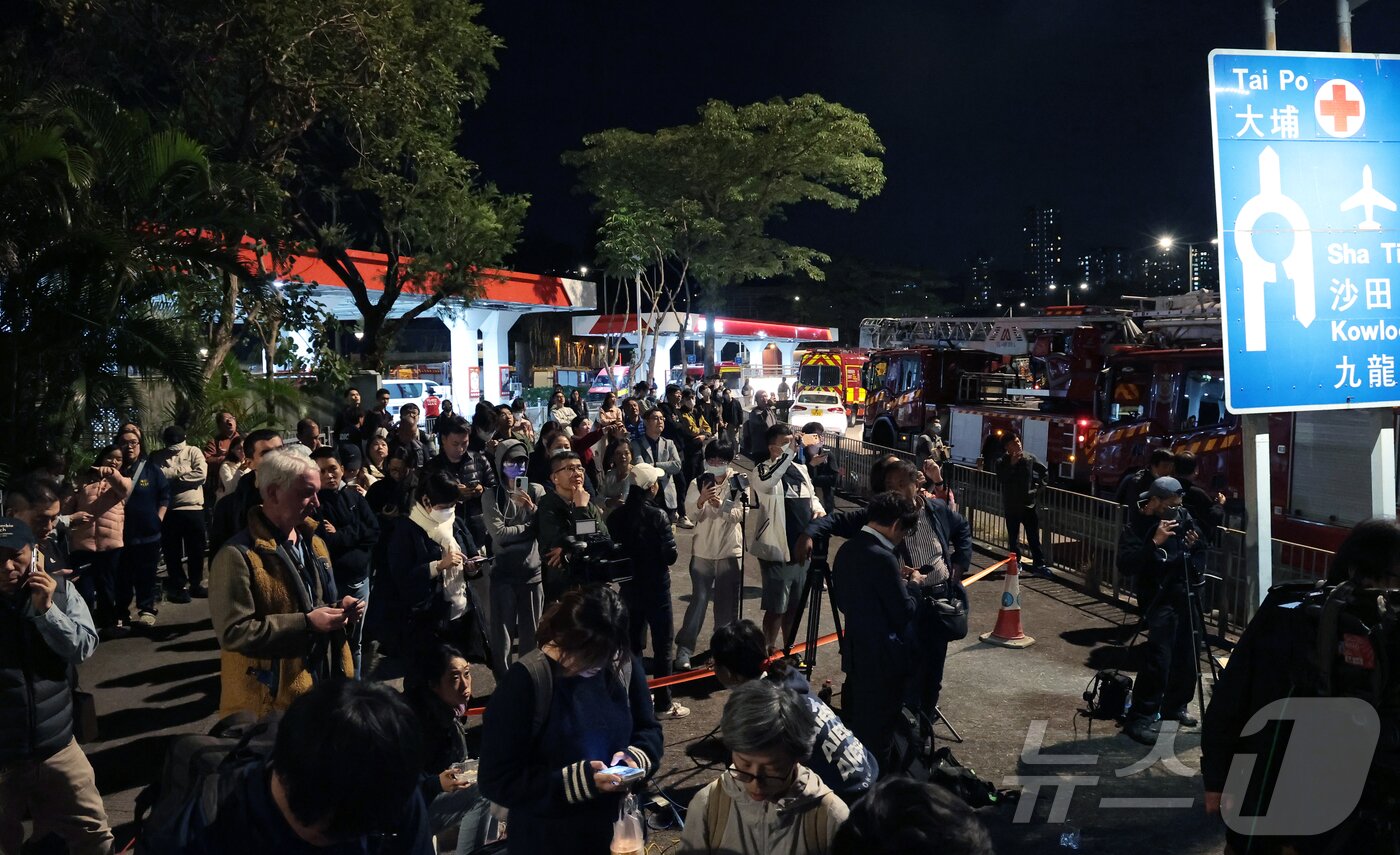 본문 이미지 - 27일 홍콩 북부 타이포 구역에서 시민들이 대형 화재 참사가 일어난 아파트 단지 웡 푹 코트&#40;Wang Fuk Court&#41;를 바라보고 있다. 2025.11.27/뉴스1 ⓒ News1 권현진 기자