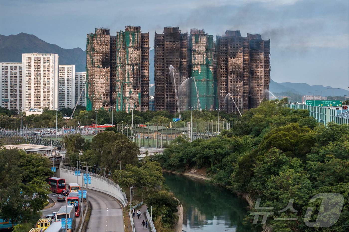 본문 이미지 - 27일 홍콩 타이포 지역 왕 푹 콕 아파트 단지 화재 현장. 주불은 진압됐지만, 아직 잔불이 남아 있어 소방 작업이 지금도 진행 중이다. ⓒ AFP=뉴스1 ⓒ News1 박형기 기자