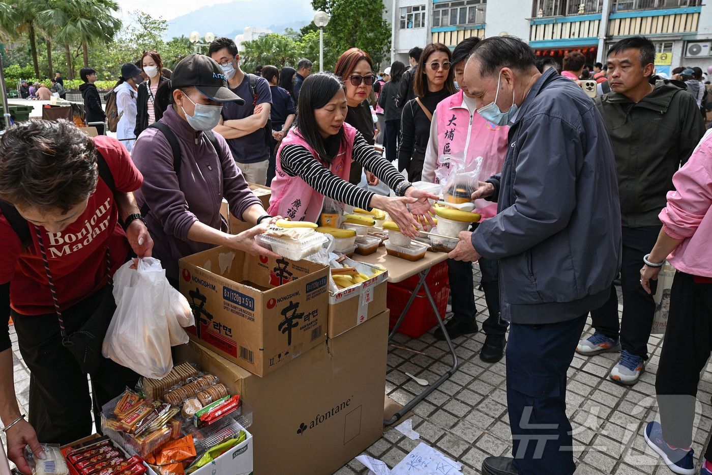 본문 이미지 - 27일 홍콩 타이포 지역 왕 푹 콕 아파트 단지 화재 현장에서 자원봉사자들이 주민들에게 음식을 나눠주고 있다. ⓒ AFP=뉴스1 ⓒ News1 임세영 기자