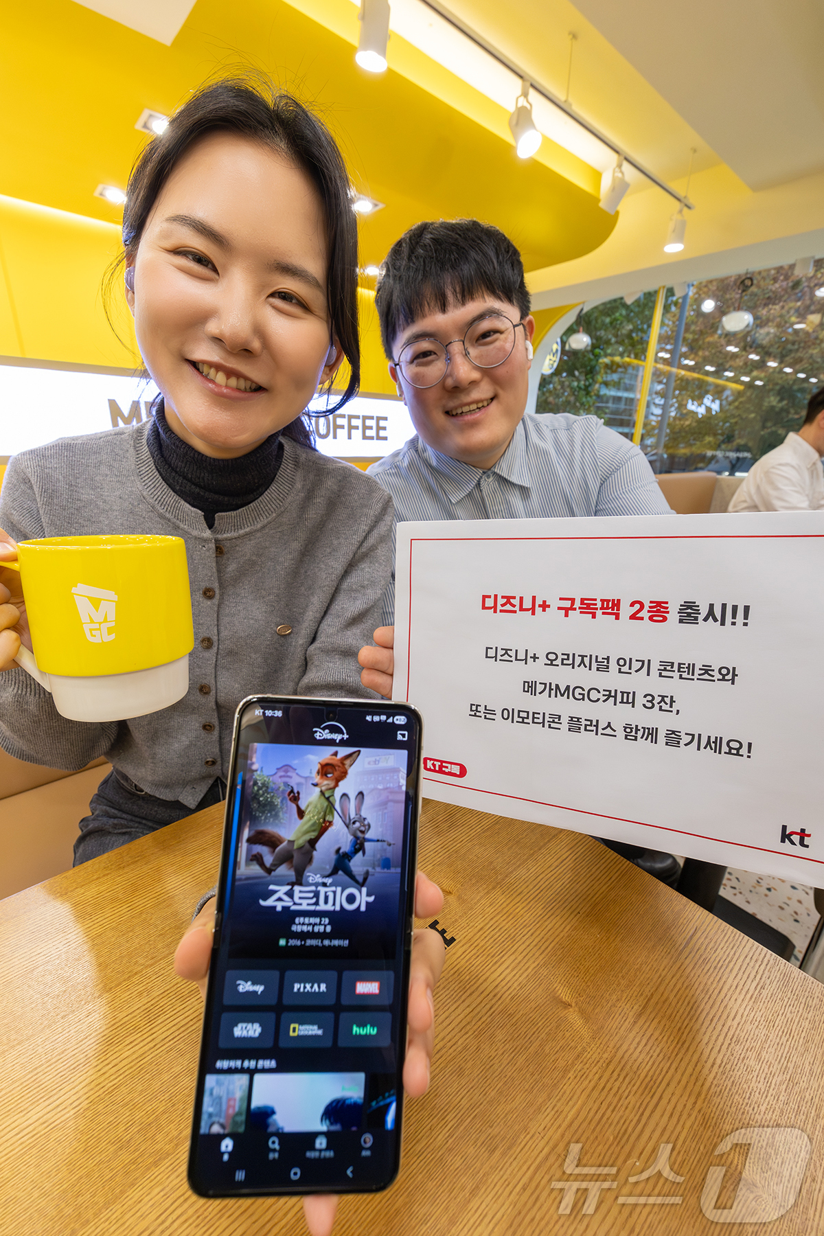 (서울=뉴스1) = KT가 디즈니+와 메가MGC커피, 생활쿠폰 혜택을 결합한 디즈니+ 구독팩을 신규 출시했다고 28일 밝혔다. 사진은 모델들이 ‘디즈니플러스+메가MGC커피’, ‘디 …