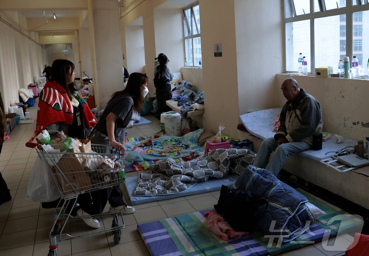 본문 이미지 - 웡 푹 코트 아파트 단지 인근 대피소에서 이재민들이 구호 물품을 전달받고 있다. 2025.11.28/뉴스1 ⓒ News1 권현진 기자