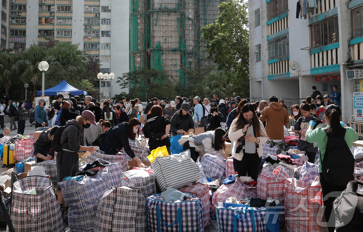 (홍콩=뉴스1) 권현진 기자 = 28일(현지시간) 홍콩 북부 타이포의 '왕 푹 코트'(Wang Fuk Court) 아파트 단지 인근에서 자원봉사자들이 화재 피해 주민들에게 기부받은 …