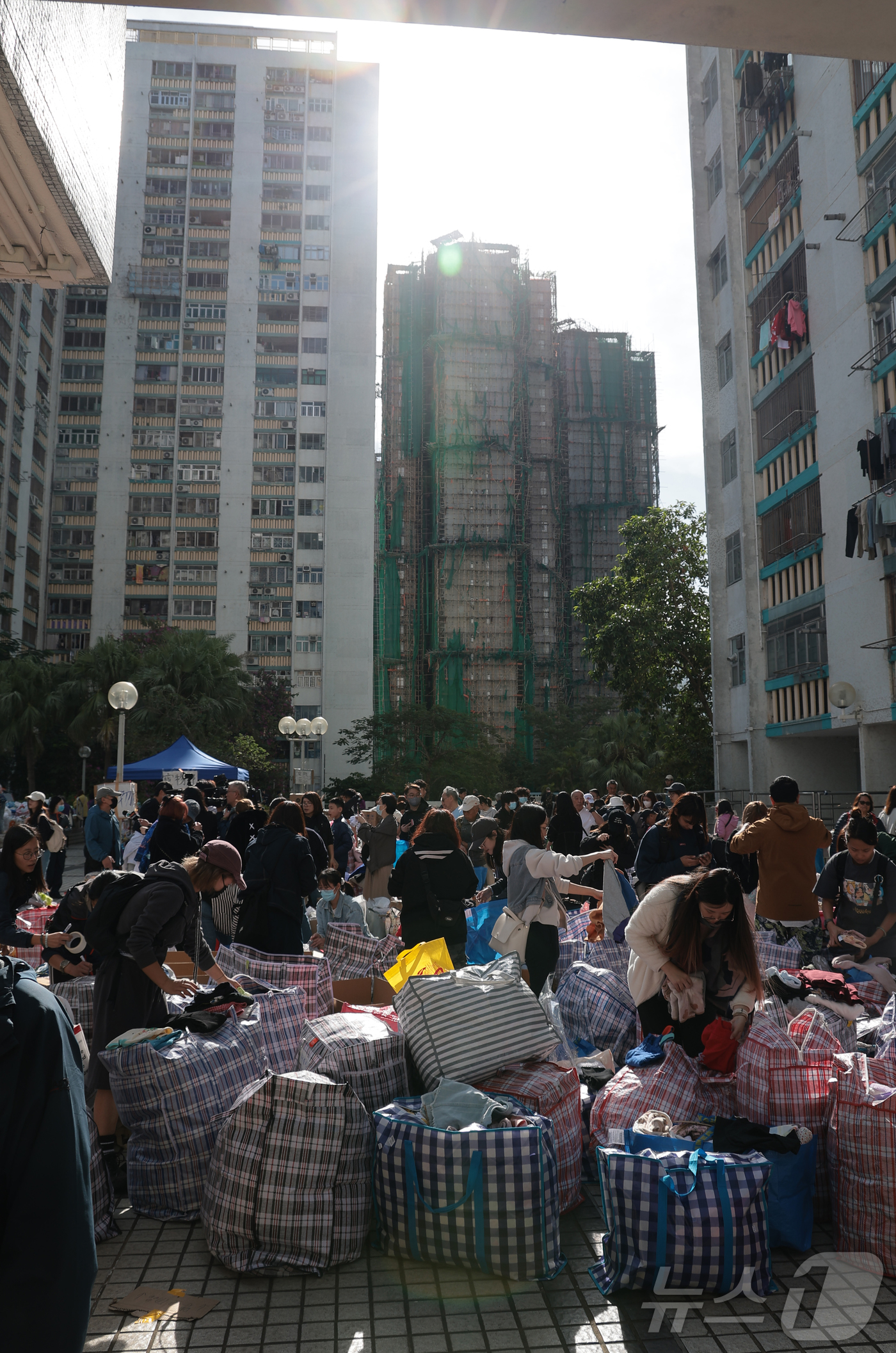 (홍콩=뉴스1) 권현진 기자 = 28일(현지시간) 홍콩 북부 타이포의 '왕 푹 코트'(Wang Fuk Court) 아파트 단지 인근에서 자원봉사자들이 화재 피해 주민들에게 기부받은 …