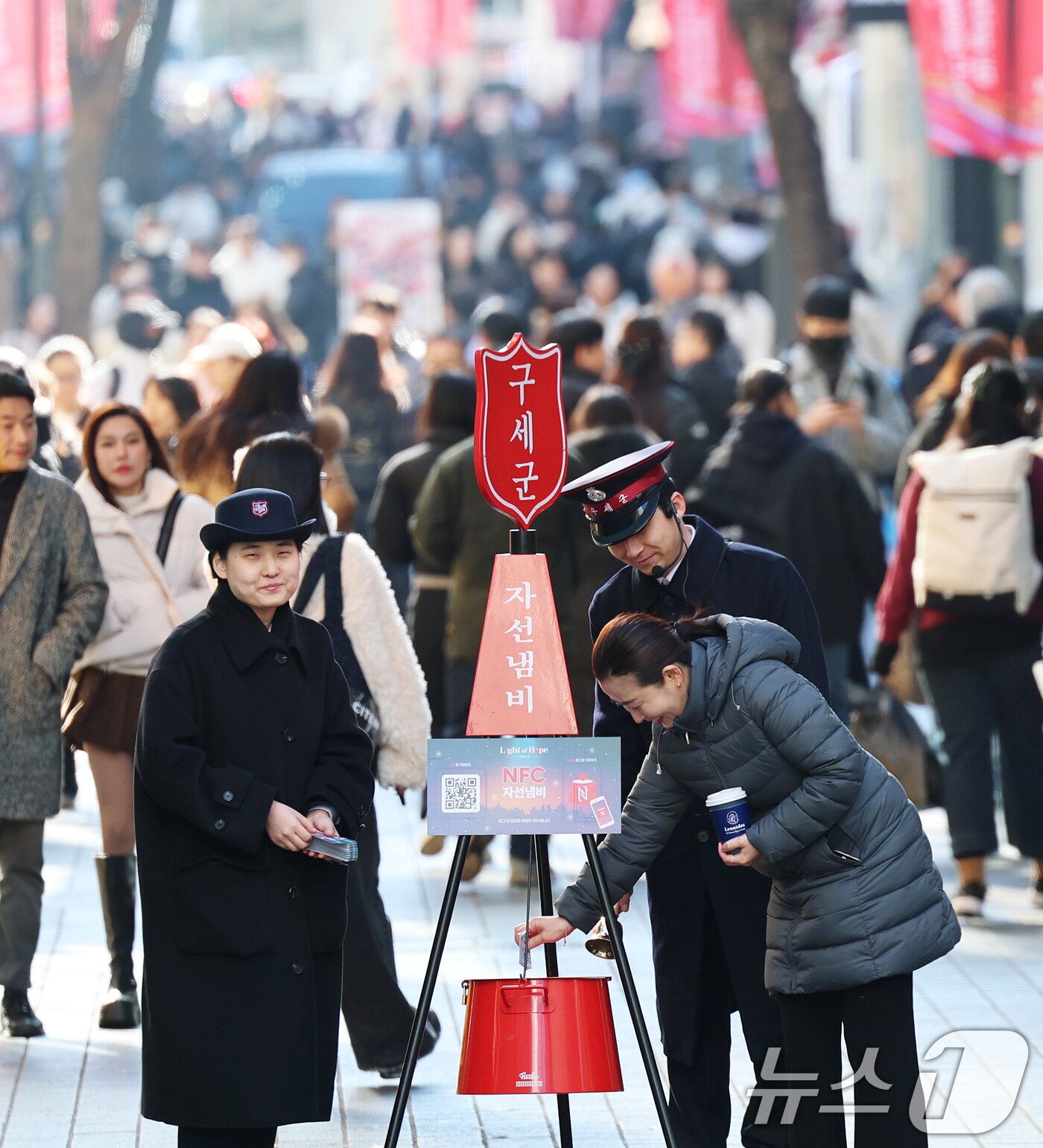 본문 이미지 - 2025 구세군 연말 모금 캠페인이 시작된 28일 오후 서울 중구 명동거리에서 시민들이 구세군 자선냄비에 기부하고 있다.  2025.11.28/뉴스1 ⓒ News1 오대일 기자