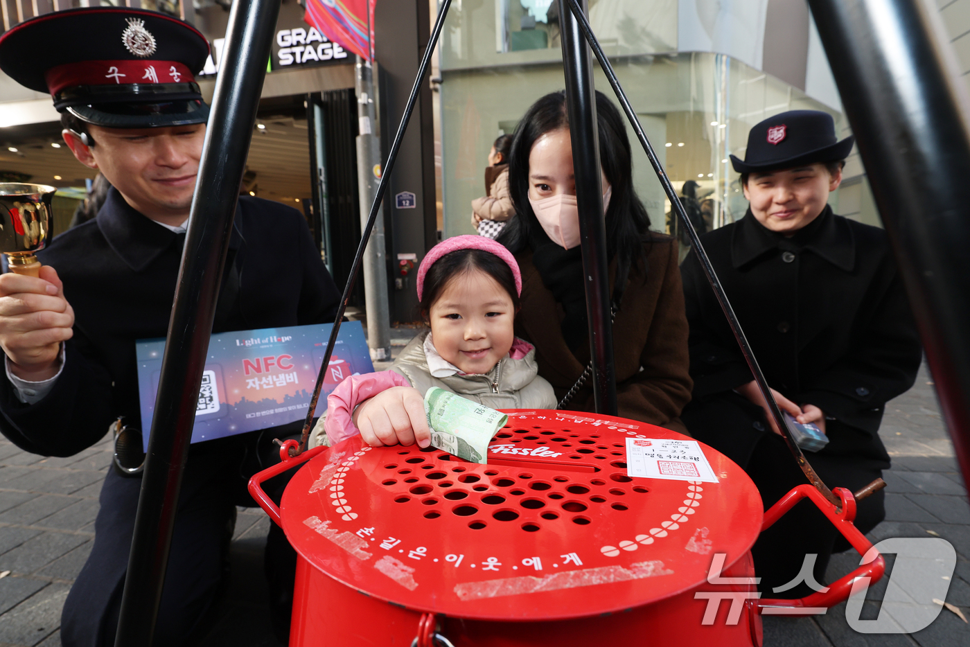 (서울=뉴스1) 오대일 기자 = 2025 구세군 연말 모금 캠페인이 시작된 28일 오후 서울 중구 명동거리에서 한 어린이가 엄마와 함께 자선냄비에 기부하고 있다.올해로 97번째를 …