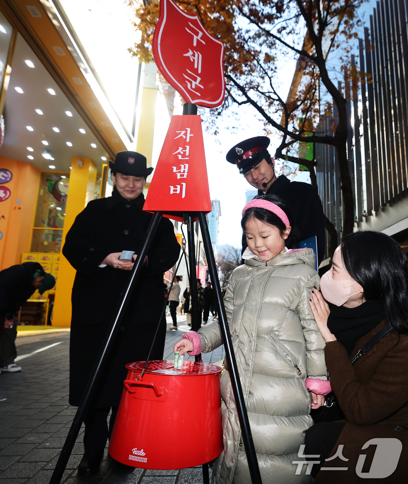 (서울=뉴스1) 오대일 기자 = 2025 구세군 연말 모금 캠페인이 시작된 28일 오후 서울 중구 명동거리에서 한 어린이가 엄마와 함께 자선냄비에 기부하고 있다.올해로 97번째를 …