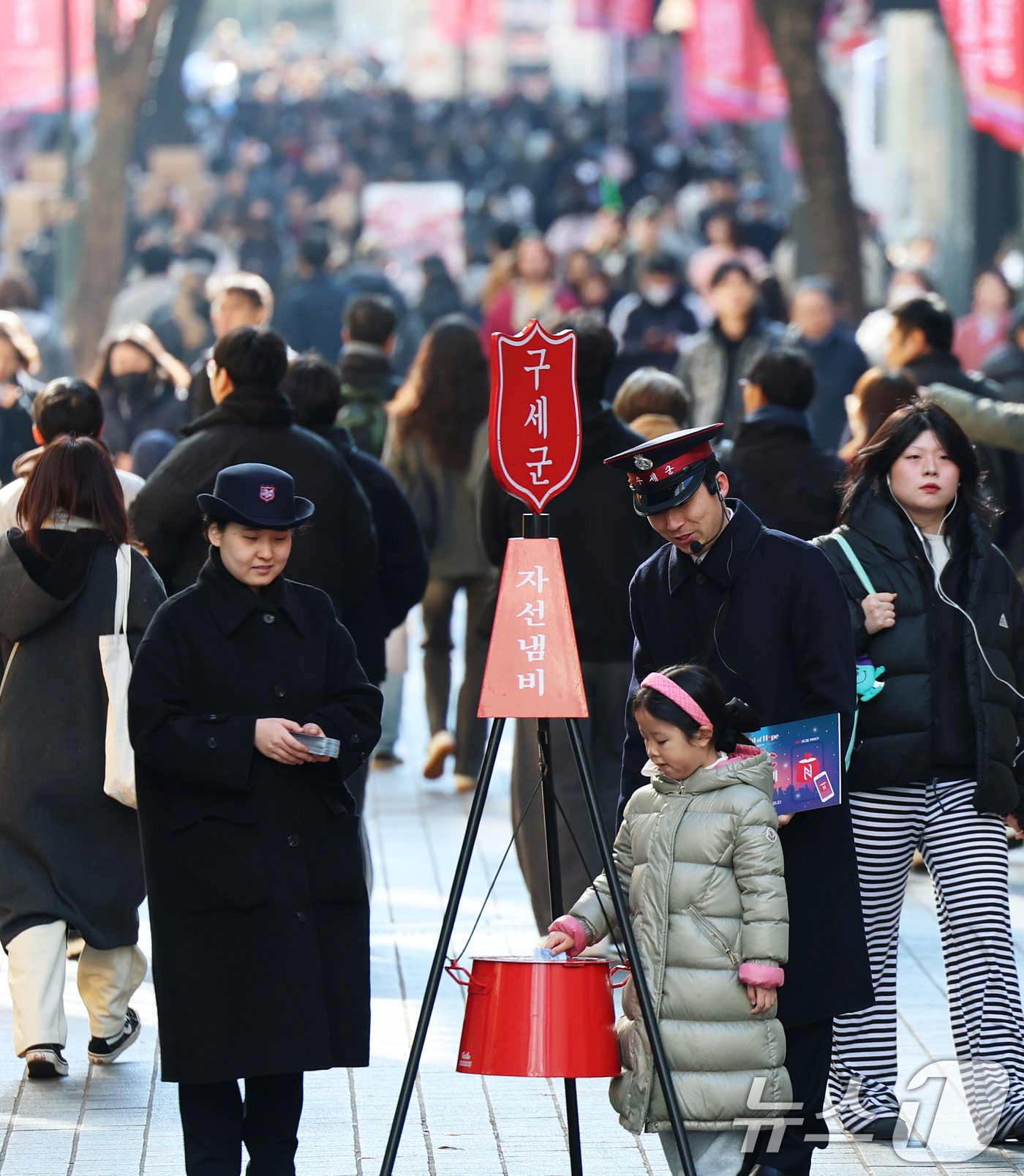 (서울=뉴스1) 오대일 기자 = 2025 구세군 연말 모금 캠페인이 시작된 28일 오후 서울 중구 명동거리에서 한 어린이가 엄마와 함께 자선냄비에 기부하고 있다.올해로 97번째를 …