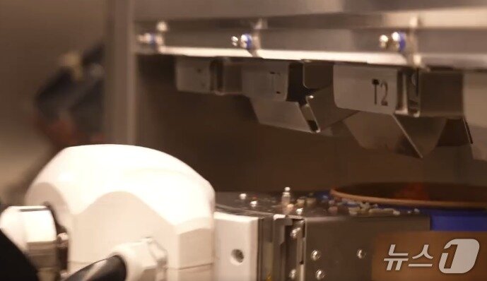 본문 이미지 - 로봇팔이 음식을 조리하고 있는 모습. &#40;주한미군 페이스북 갈무리&#41;