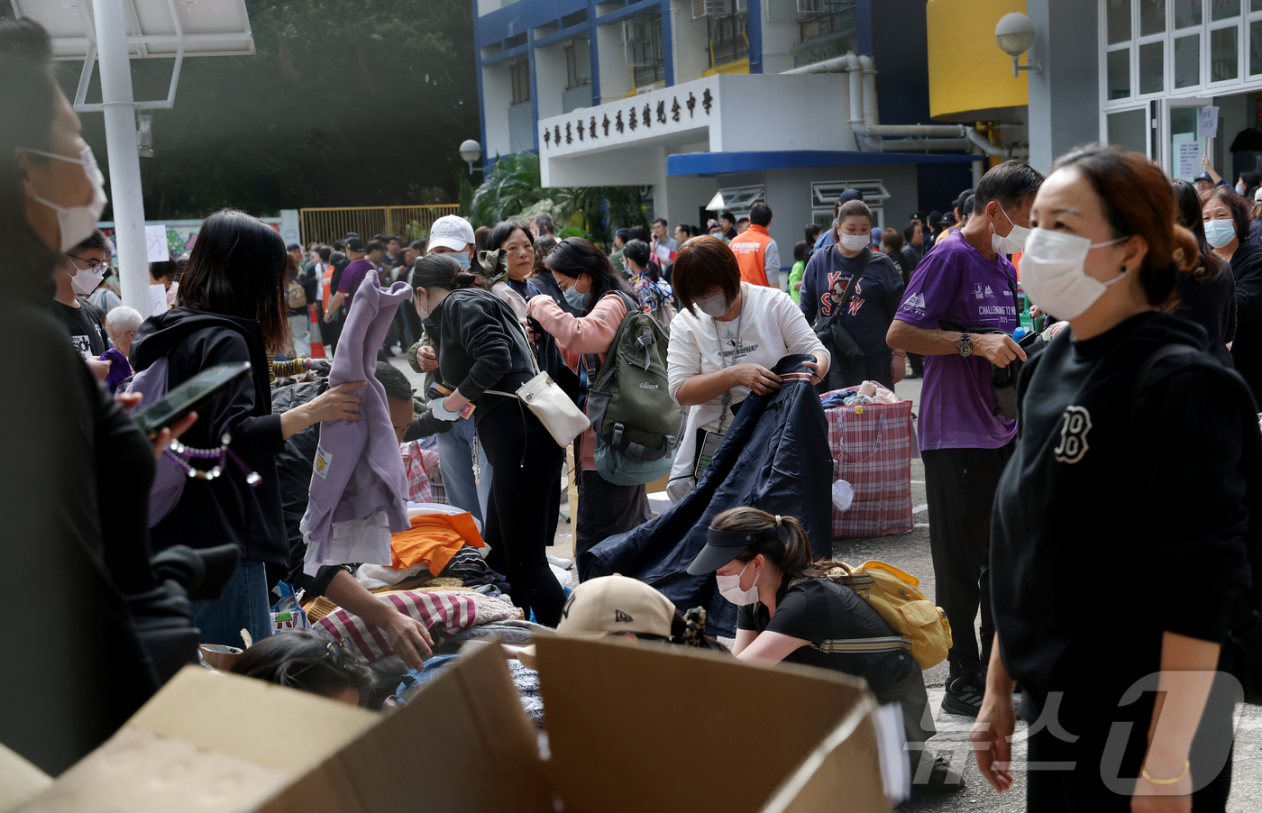 (홍콩=뉴스1) 권현진 기자 = 29일(현지시간) 홍콩 북부 타이포의 '왕 푹 코트'(Wang Fuk Court) 아파트 단지 인근 PHAB 센터에서 이재민들이 구호물품을 받고 있 …