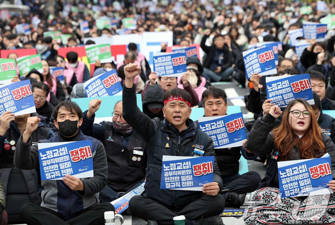 (서울=뉴스1) 이호윤 기자 = 공공운수노조 엄길용 위원장(앞줄 가운데)과 조합원들이 29일 서울 용산구 삼각지역 인근에서 열린 '공공운수노조 총력투쟁 결의대회'에서 노정교섭 법제 …