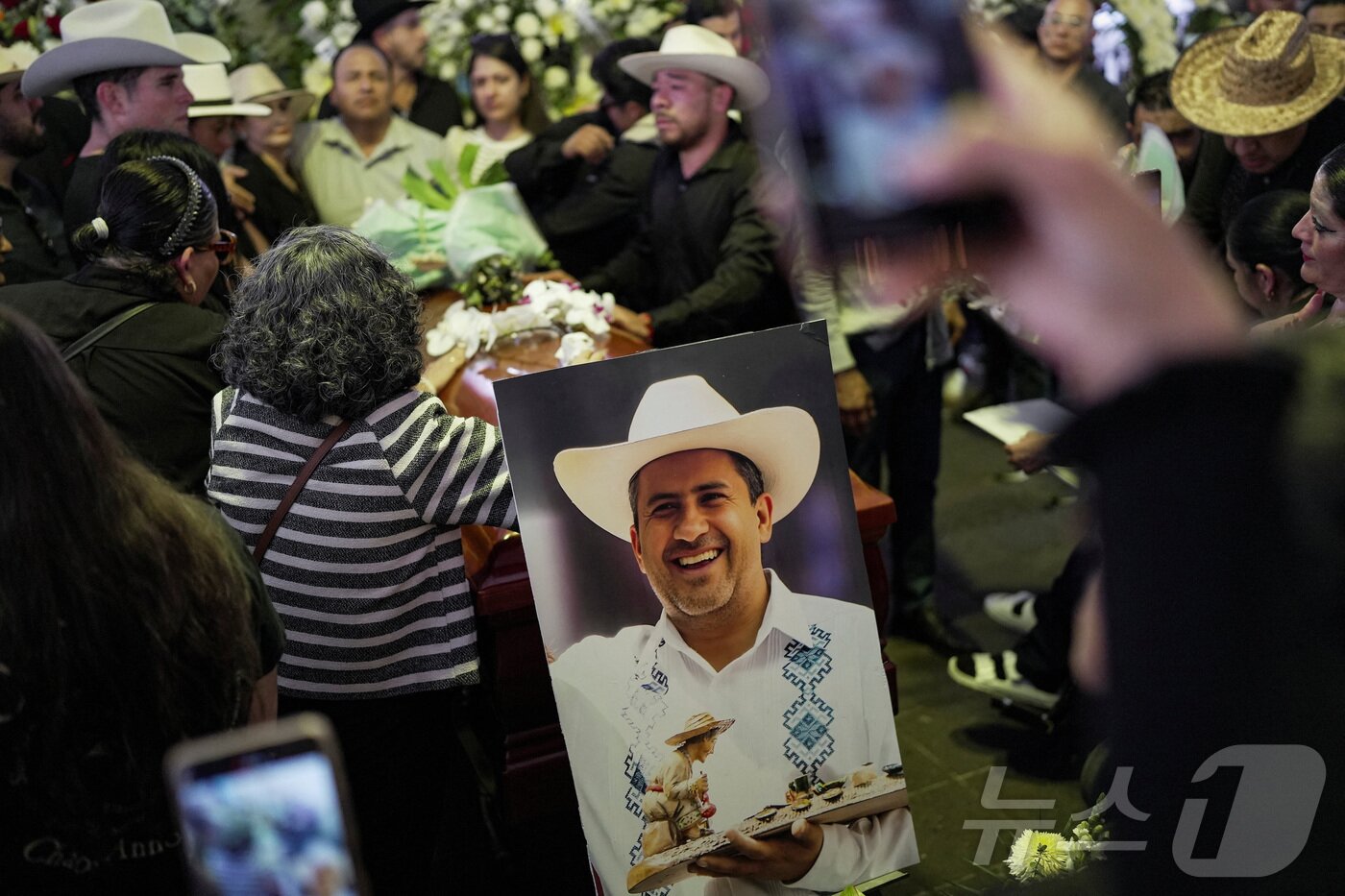 본문 이미지 - 2일&#40;현지시간&#41; 멕시코 우루아판에서 열린 죽음의 날 행사 중 총에 맞아 사망한 카를로스 만조 시장의 장례식에 가족과 친구들이 참석했다. 2025.11.03. ⓒ 로이터=뉴스1 ⓒ News1 이정환 기자