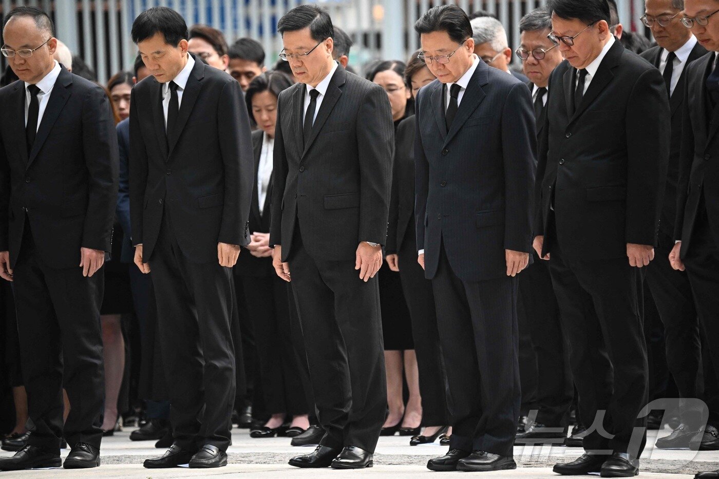 본문 이미지 - 존 리 행정장관&#40;앞줄 가운데&#41; 등 홍콩 정청의 간부들이 정부청사 앞에서 아파트 화재 참사에 희생된 이들을 위해  3분간 묵념하고 있다. ⓒ AFP=뉴스1 ⓒ News1 박형기 기자