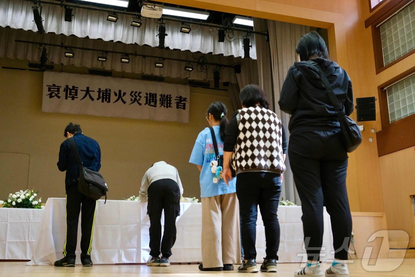 본문 이미지 - 29일 홍콩 타이포 지역에 설치된 아파트 화재 희생자 분향소에서 시민들이 희생자의 넋을 기리고 있다. ⓒ AFP=뉴스1 ⓒ News1 박형기 기자