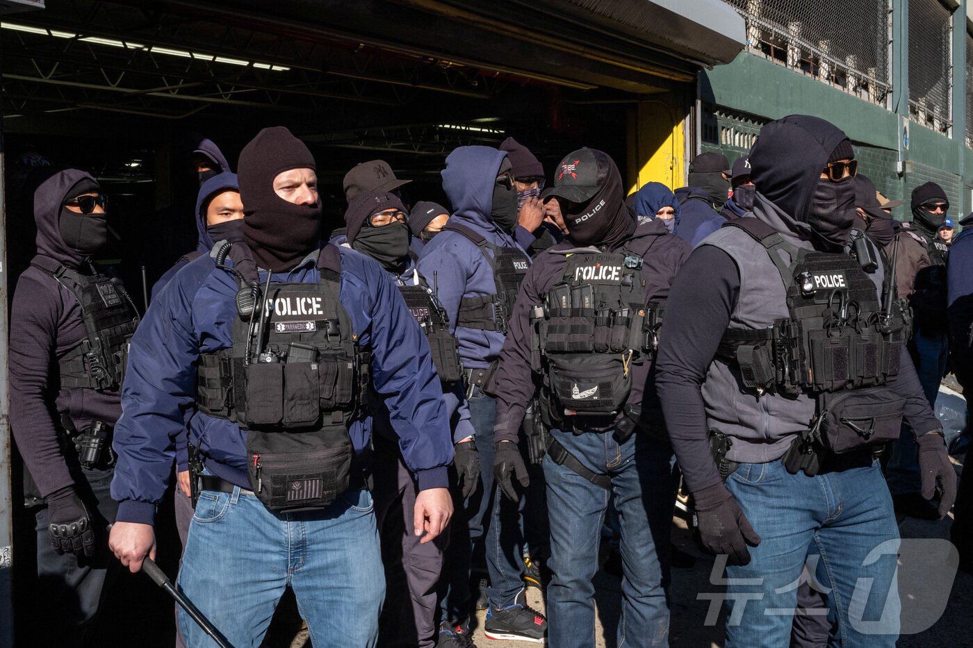 본문 이미지 - 경찰과 미국 이민세관단속국&#40;ICE&#41; 요원들이 29일 뉴욕시 맨해튼 구역의 일반 서비스 관리국&#40;GSA&#41; 주차장 근처에 사람들이 모이는 것을 지켜보고 있다. 2025.11.29 ⓒ 로이터=뉴스1 ⓒ News1 강민경 기자