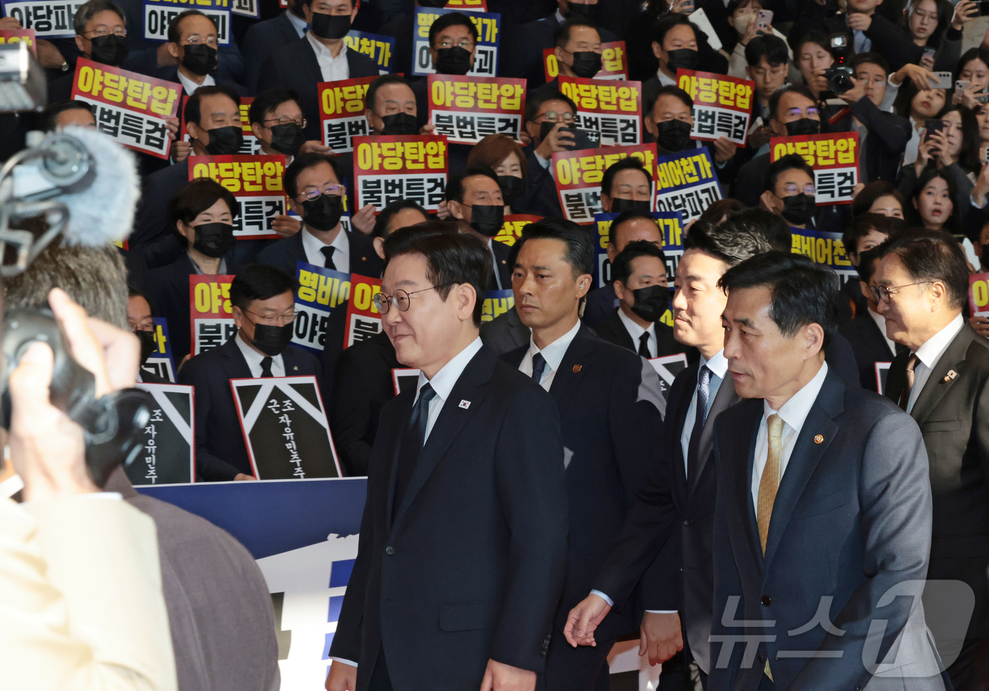 (서울=뉴스1) 국회사진기자단 = 이재명 대통령이 4일 오전 서울 여의도 국회에서 시정연설을 위해 이동하는 가운데 국민의힘 의원들이 검은 양복과 넥타이를 메고 마스크를 착용한 채 …