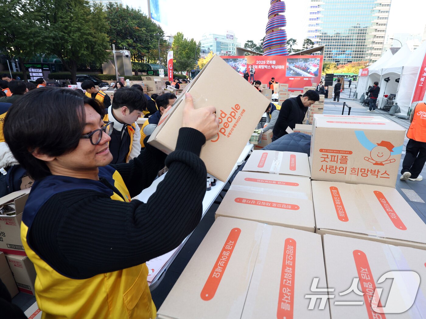 본문 이미지 - 4일 오전 서울 청계광장에서 열린 &#39;2025 굿피플 사랑의 희망박스 박싱데이&#39;에서 봉사자들이 식료품 16종을 상자에 담고 있다. 2025.11.4/뉴스1 ⓒ News1 황기선 기자