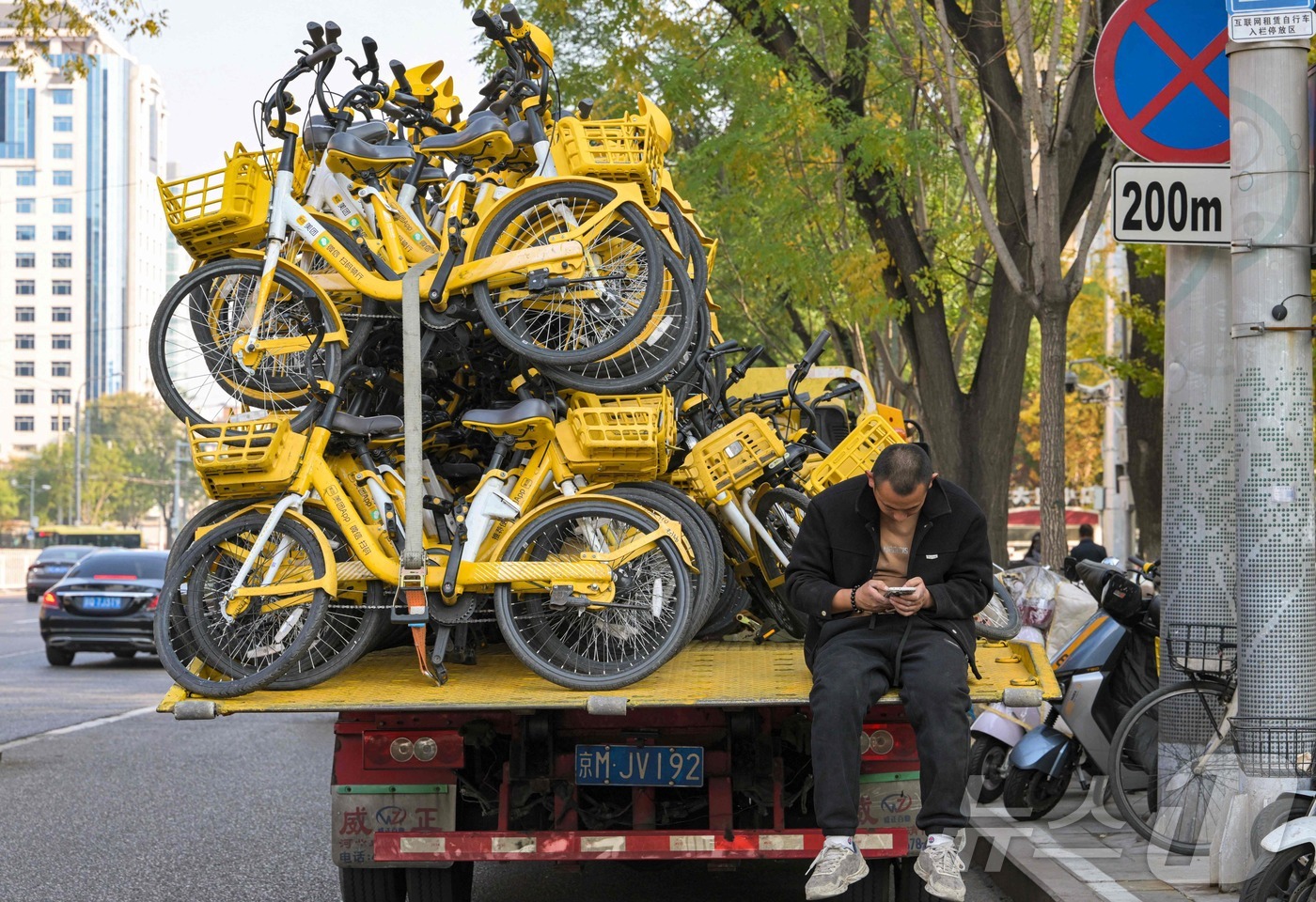 (베이징 AFP=뉴스1) 이정환 기자 = 4일(현지시간) 베이징에서 공유 자전거를 실은 트럭 위에 한 남자가 앉아 있다. 2025.11.04.ⓒ AFP=뉴스1
