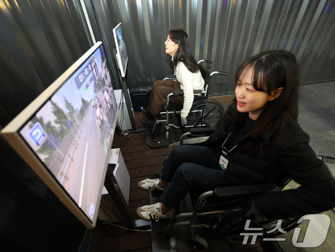 (고양=뉴스1) 황기선 기자 = 5일 경기 고양시 일산서구 킨텍스에서 열린 '2025 디지털퓨처쇼'에서 관람객들이 한국AI실감메타버스콘텐츠협회가 운영하는 ‘휠체어 레이스’를 체험하 …