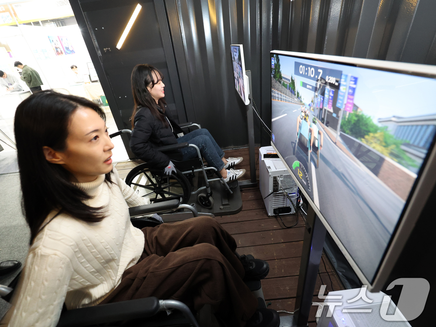 (고양=뉴스1) 황기선 기자 = 5일 경기 고양시 일산서구 킨텍스에서 열린 '2025 디지털퓨처쇼'에서 관람객들이 한국AI실감메타버스콘텐츠협회가 운영하는 ‘휠체어 레이스’를 체험하 …