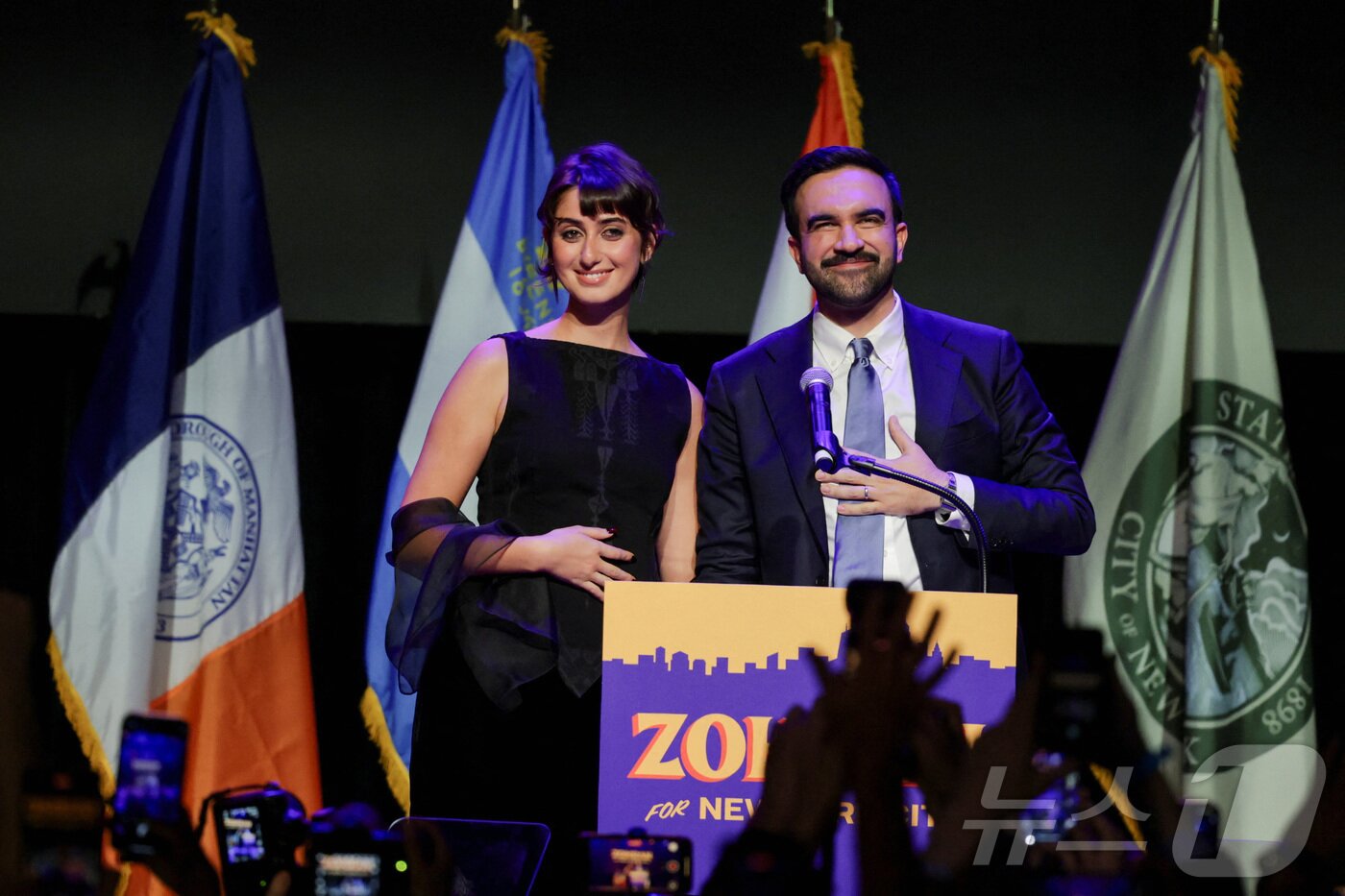 본문 이미지 - 민주당 조란 맘다니&#40;34&#41;가 4일&#40;현지시간&#41; 뉴욕 브루클린에서 배우자 라마 두와지와 함께 무대에 올라 기뻐하고 있다. 맘다니는 이날 치러진 뉴욕시장 선거에서 개표율 90% 기준 50.4%&#40;102만 9196표&#41;를 득표하면서 41.6%&#40;84만 9816표&#41;를 득표한 앤드루 쿠오모 무소속 후보를 큰 표차로 따돌리며 차기 뉴욕시장으로 당선됐다. ⓒ 로이터=뉴스1 ⓒ News1 윤다정 기자