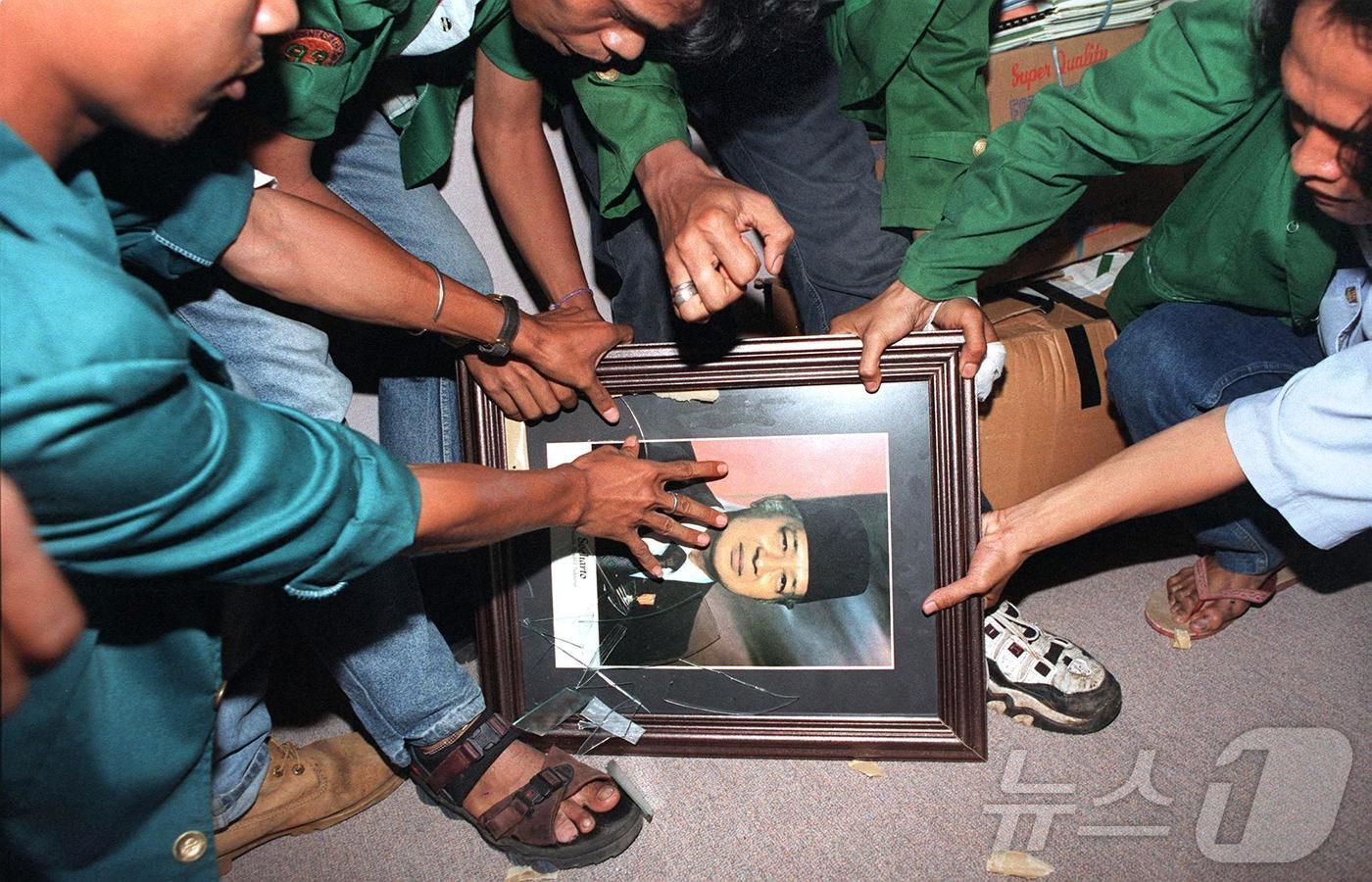 본문 이미지 - 수하르토 정권이 축출된 1998년 5월 21일 자카르타 의회 건물 사무실에서 인도네시아 학생들이 수하르토 전 대통령의 초상화를 부수고 있다. ⓒ AFP=뉴스1 ⓒ News1 이정환 기자
