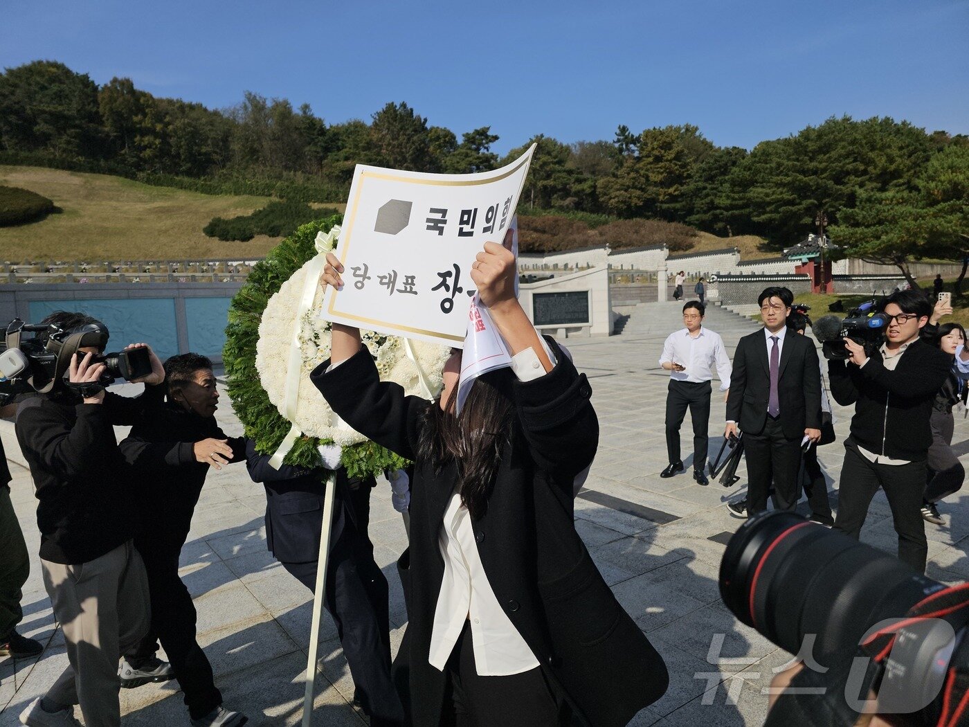 본문 이미지 - 6일 광주 북구 운정동 5·18민주묘지에서 장동혁 국민의힘 대표의 참배를 저지하는 광주 시민들이 조화와 명패를 철거고 있다. 2025.11.6/뉴스1 ⓒ News1 서충섭 기자