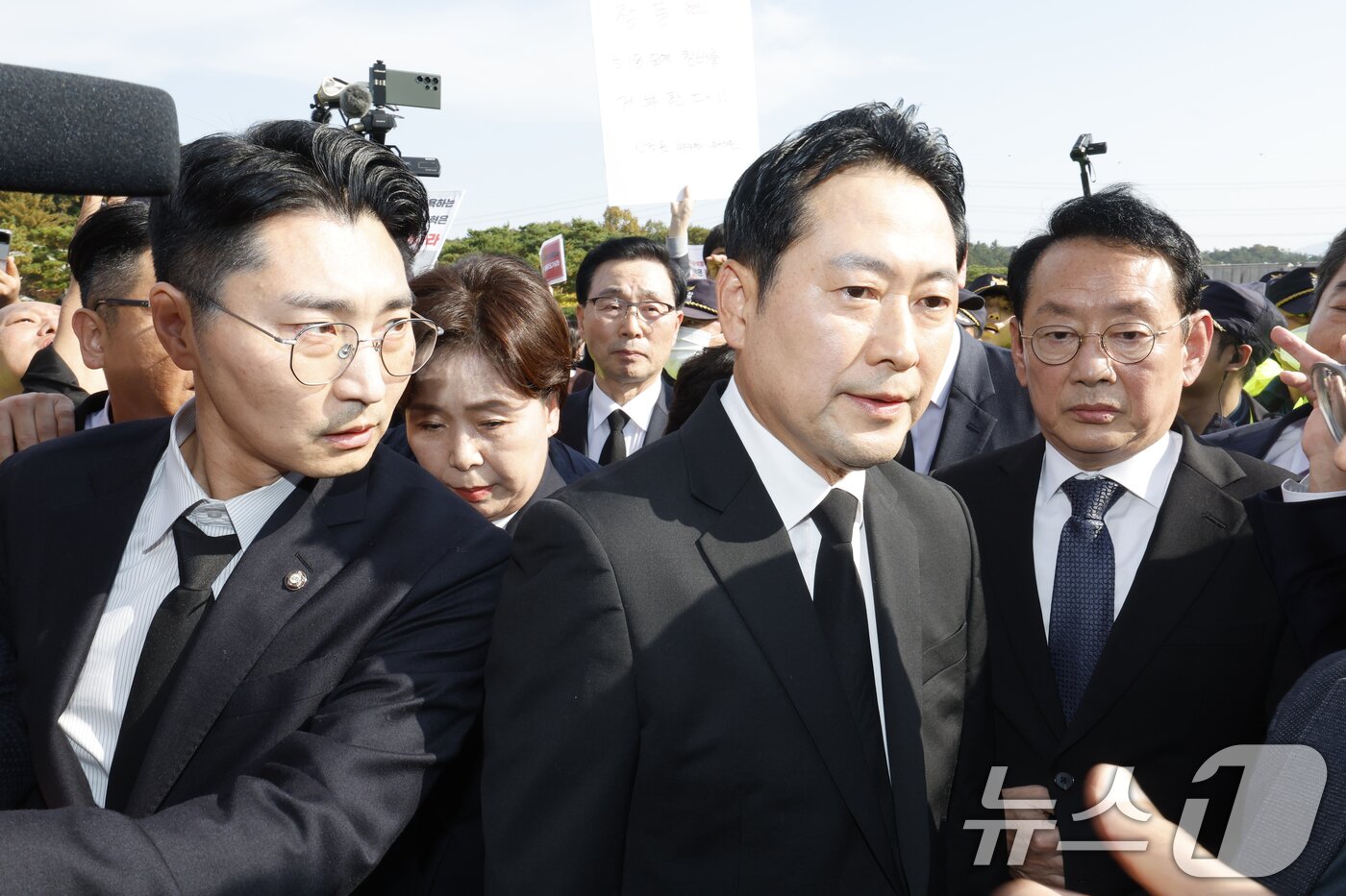 본문 이미지 - 장동혁 국민의힘 대표가 6일 광주 국립 5·18민주묘지를 막아서는 광주전남촛불행동 회원들에게 둘러쌓여 참배를 못하고 돌아서고 있다. 2025.11.6/뉴스1 ⓒ News1 김태성 기자