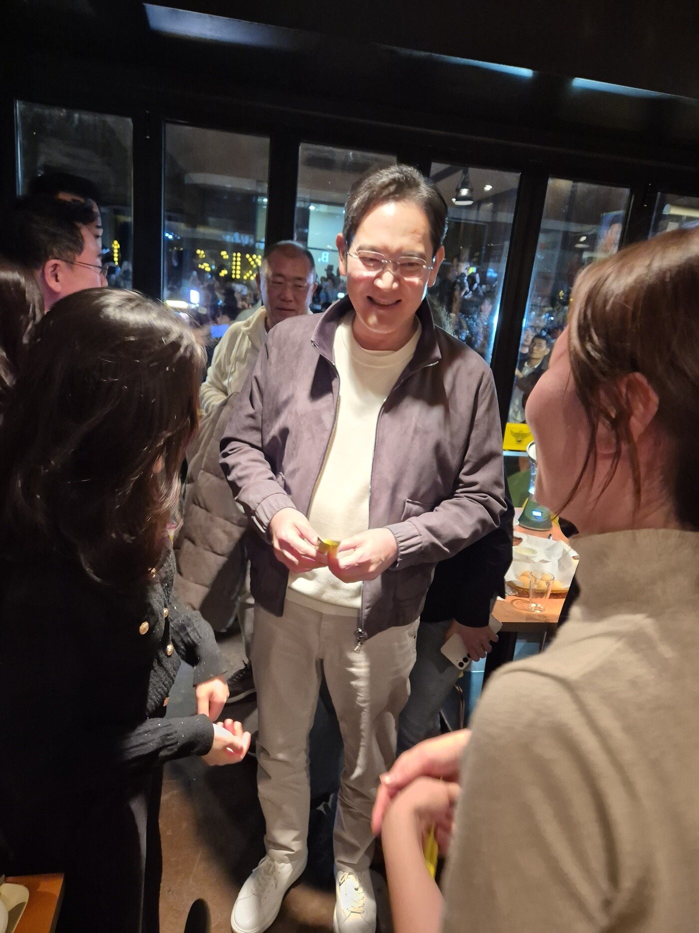 본문 이미지 -  지난달 30일 깐부치킨 삼성점에서 이재용 삼성전자 회장이 매장 방문 고객들과 대화를 나누는 모습.&#40;강혜지 하이트진로 사원 제공&#41;