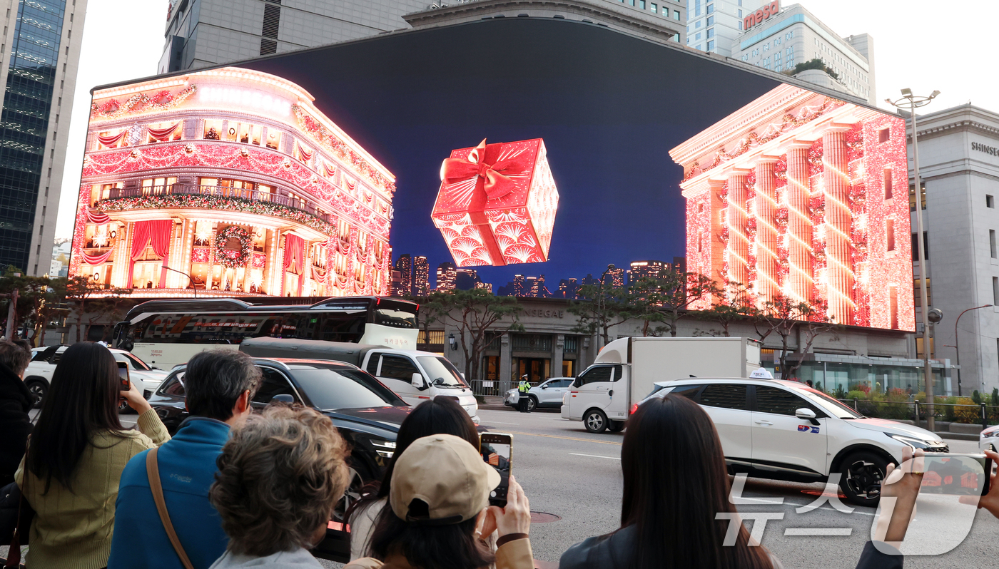 (서울=뉴스1) 김명섭 기자 = 7일 오후 서울 중구 신세계 스퀘어에 공개된 '시간을 잇는 마법의 세계'라는 주제의 크리스마스 영상을 시민들이 지켜보고 있다.총 3분여 가량의 이번 …