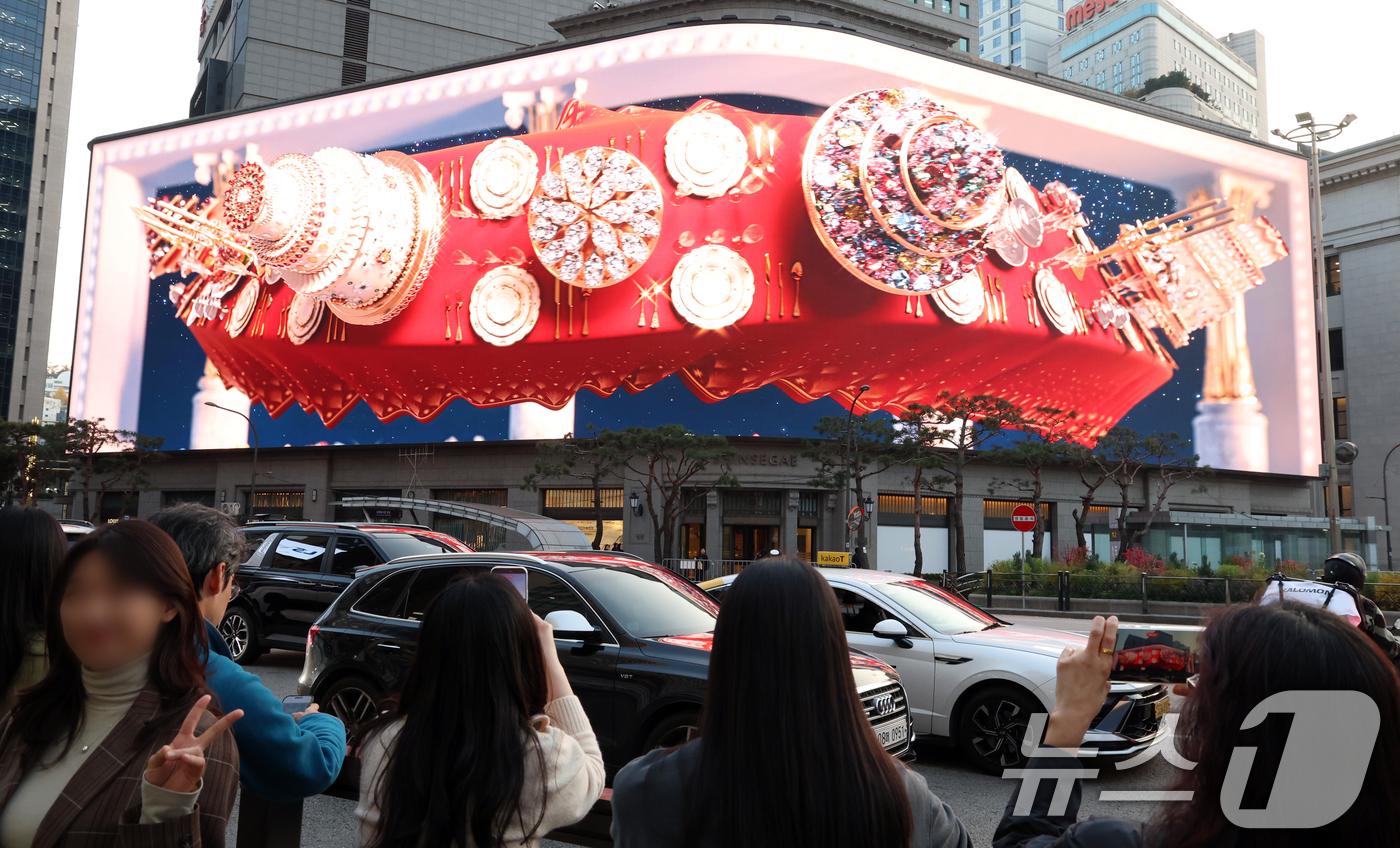 (서울=뉴스1) 김명섭 기자 = 7일 오후 서울 중구 신세계 스퀘어에 공개된 '시간을 잇는 마법의 세계'라는 주제의 크리스마스 영상을 시민들이 지켜보고 있다.총 3분여 가량의 이번 …