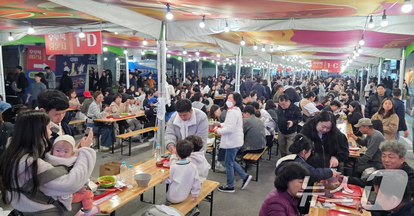 본문 이미지 - 7일 개막한 구미라면축제에 9만명의 인파가 몰리고 농심의 갓 튀긴 라면이 10만개 팔리면서 대박조짐을 보이고 있다. 방문객들이 라면 취식존에서 라면을 먹고 있다. 2025.11.7/뉴스1 ⓒ News1 정우용 기자