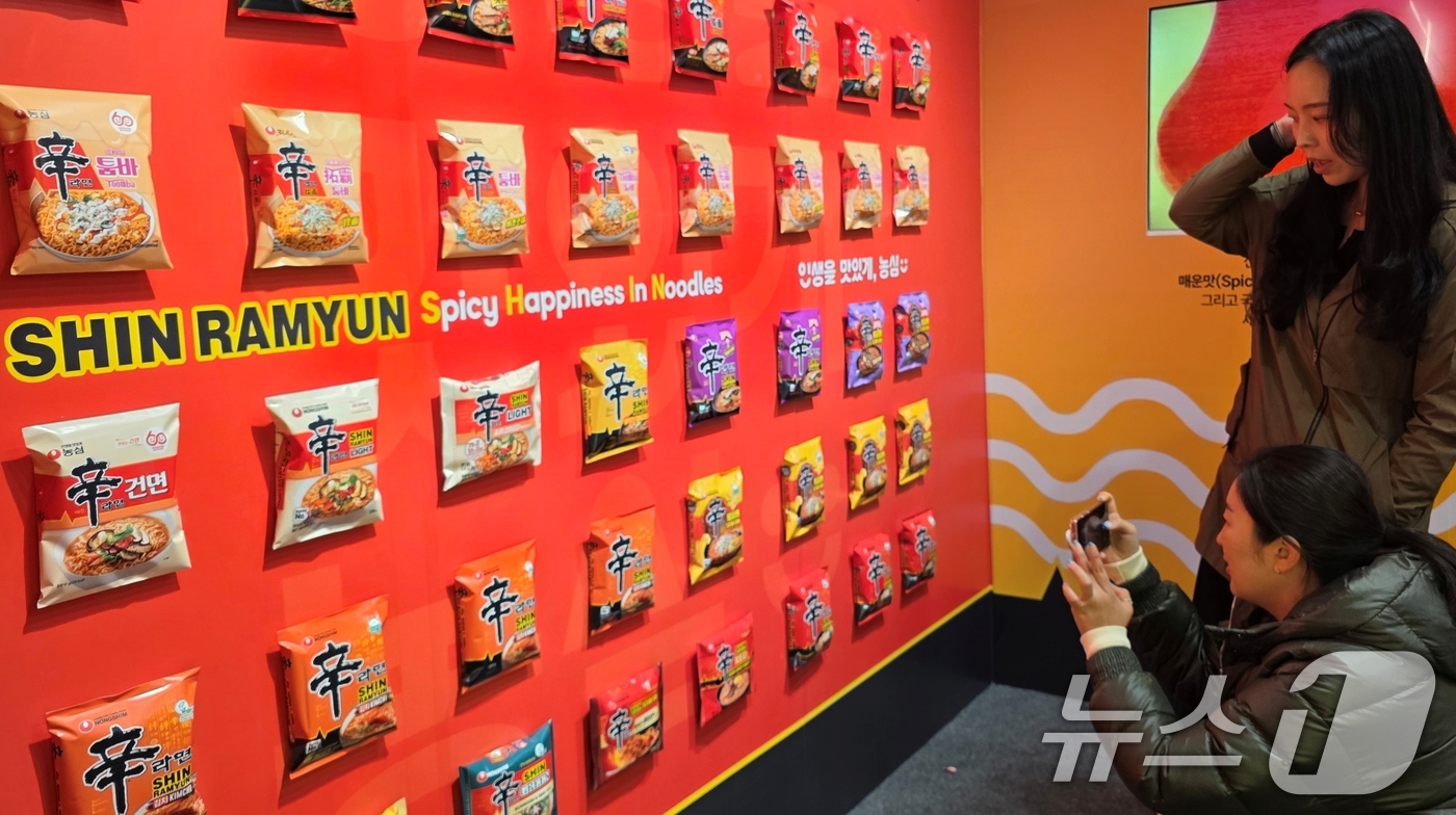 (구미=뉴스1) 정우용 기자 = 7일 경북 구미시 구미역 앞에서 열린 '2025 구미라면축제' 행사장을 찾은 방문객들이 생산된 라면 봉지 등을 전시한 부스에서 신기한 듯 사진을 찍 …