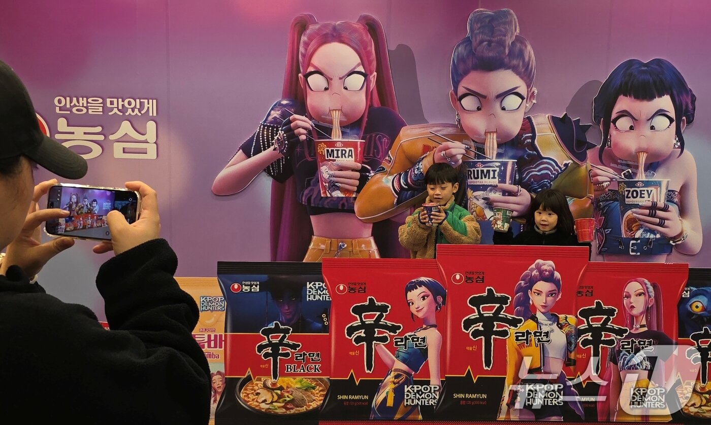 본문 이미지 - 7일 경북 구미시 구미역 앞에서 열린 &#39;2025 구미라면축제&#39; 행사장을 찾은 방문객들이 넷플릭스 애니메이션 영화 &#39;케이팝 데몬 헌터스&#39; 가 라면을 먹는 모습을 배경으로 기념사진을 찍고 있다. 라면축제는 오는 9일까지 구미역 일대에서 열린다. 2025.11.7/뉴스1 ⓒ News1 정우용 기자
