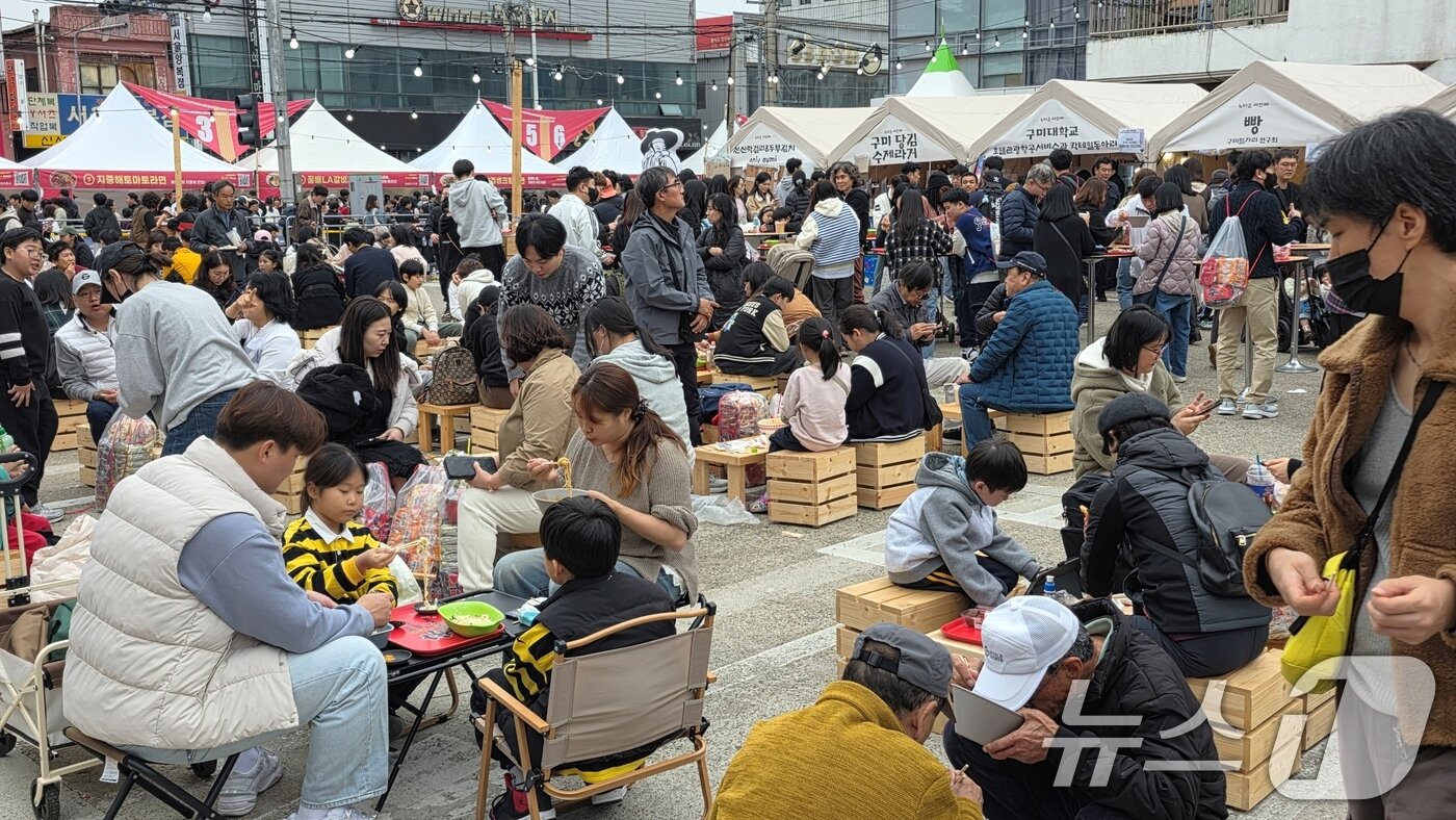 본문 이미지 - 8일 경북 구미에서 열리고 있는 &#39;2025 구미라면축제&#39;를 찾은 방문객들이 &#39;호로록 시식 장소&#39;에서 주문한 라면을 먹고 있다. 라면축제는 오는 9일까지 구미역 일대에서 계속된다. 2025.11.8/뉴스1 ⓒ News1 정우용 기자