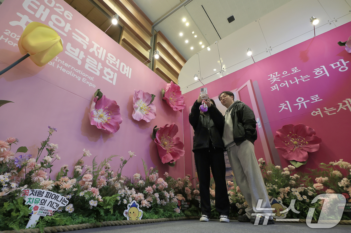 (서울=뉴스1) 박정호 기자 = 9일 서울 강남구 삼성동 코엑스에서 진행 중인 트래블쇼 2025를 찾은 관람객들이 충청남도 부스에 마련된 2026 태안국제원예치유박람회 포토월에서 …