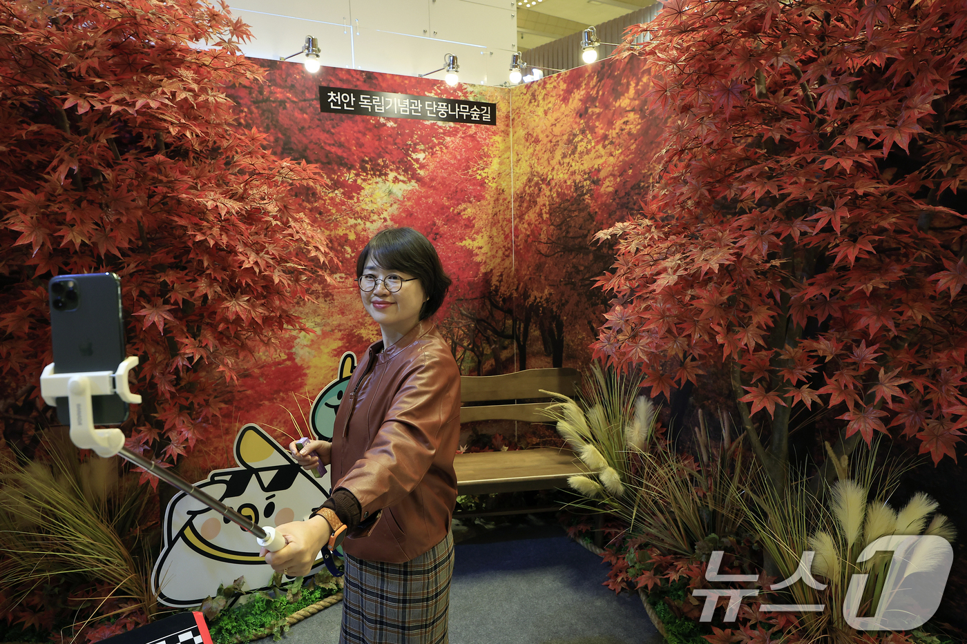 (서울=뉴스1) 박정호 기자 = 9일 서울 강남구 삼성동 코엑스에서 진행 중인 트래블쇼 2025를 찾은 관람객이 천안시 부스에 마련된 천안 독립기념관 단풍나무숲길 포토월에서 기념사 …