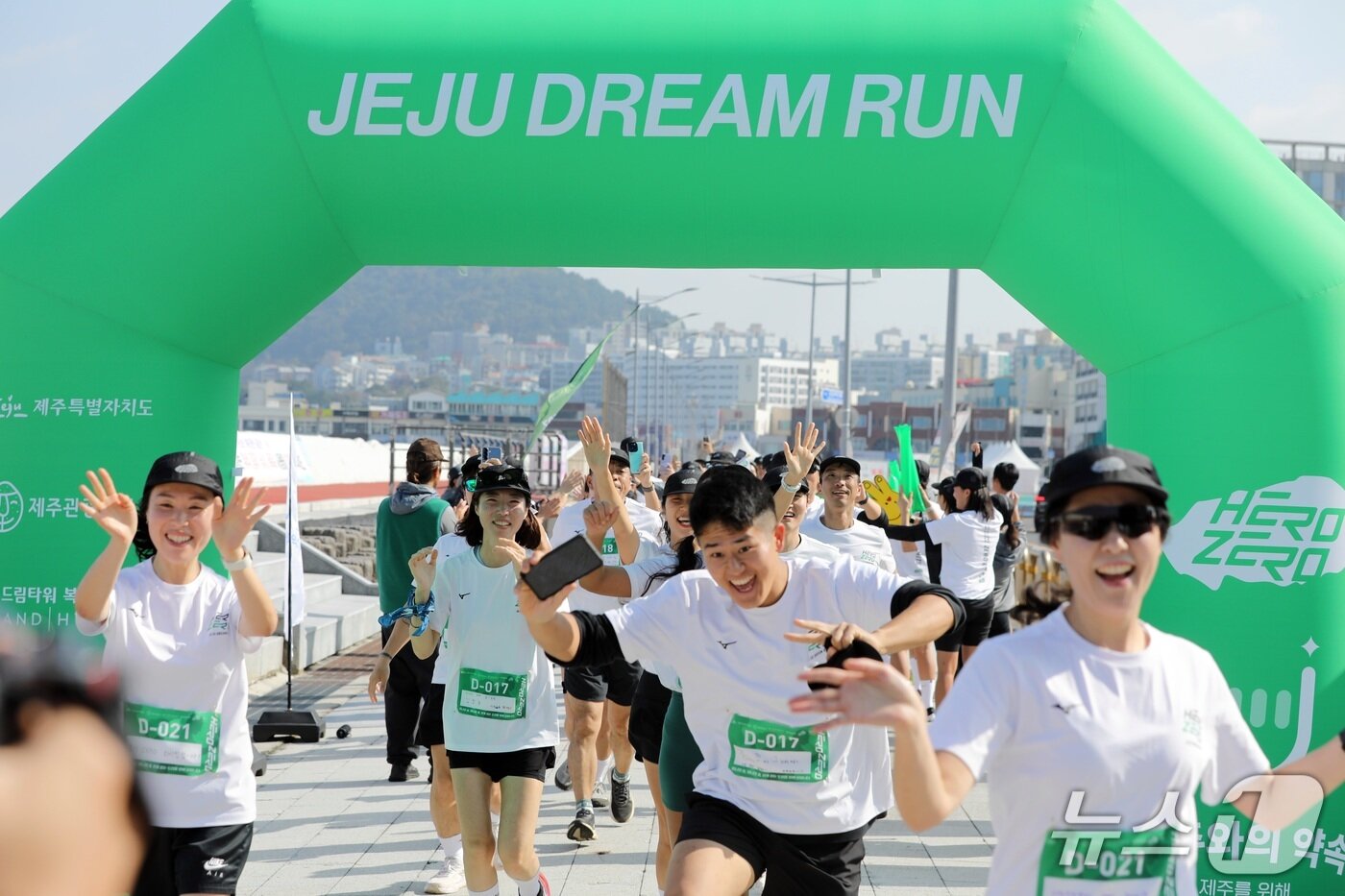 본문 이미지 -   '히어로 앤 제로, 제주 드림런' 참가자들이 9일 오후 제주 탑동광장에 설치된 골인 지점을 통과하고 있다/뉴스1