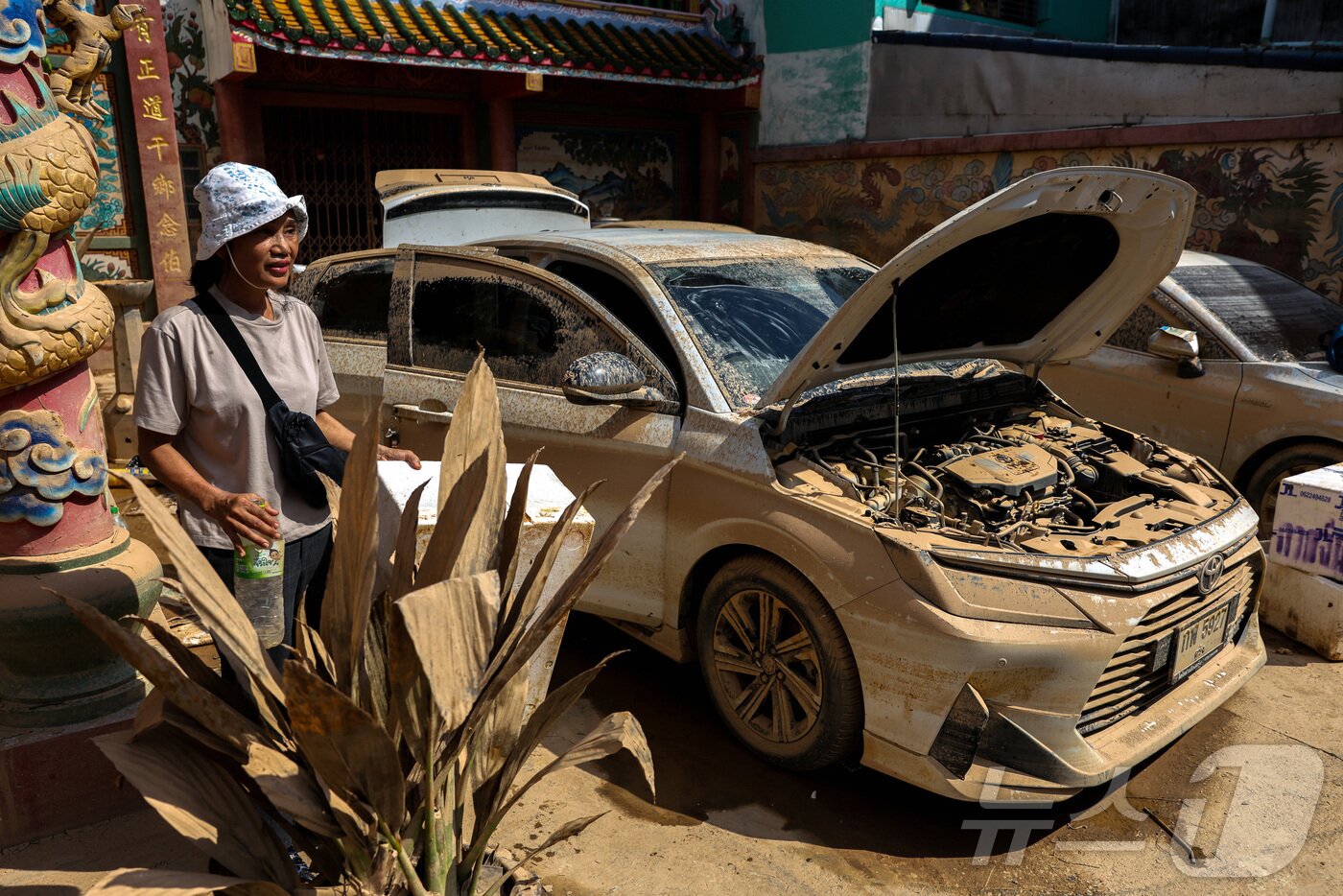 본문 이미지 - 지난달 30일&#40;현지시간&#41; 태국 송클라주 핫야이에서 치명적인 홍수로 인해 손상된 차량 옆에 한 여성이 서 있다. 2025.11.30. ⓒ 로이터=뉴스1 ⓒ News1 이정환 기자