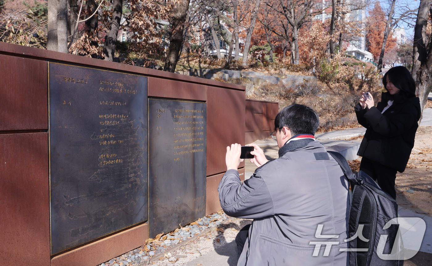 (서울=뉴스1) 박지혜 기자 = 1일 서울 서대문구 연세대학교 문동주 문학동산에서 제막된 한강 작가의 시(詩) 동판을 학생들이 살펴보고 있다. 연세대는 한강 작가의 노벨문학상 수상 …