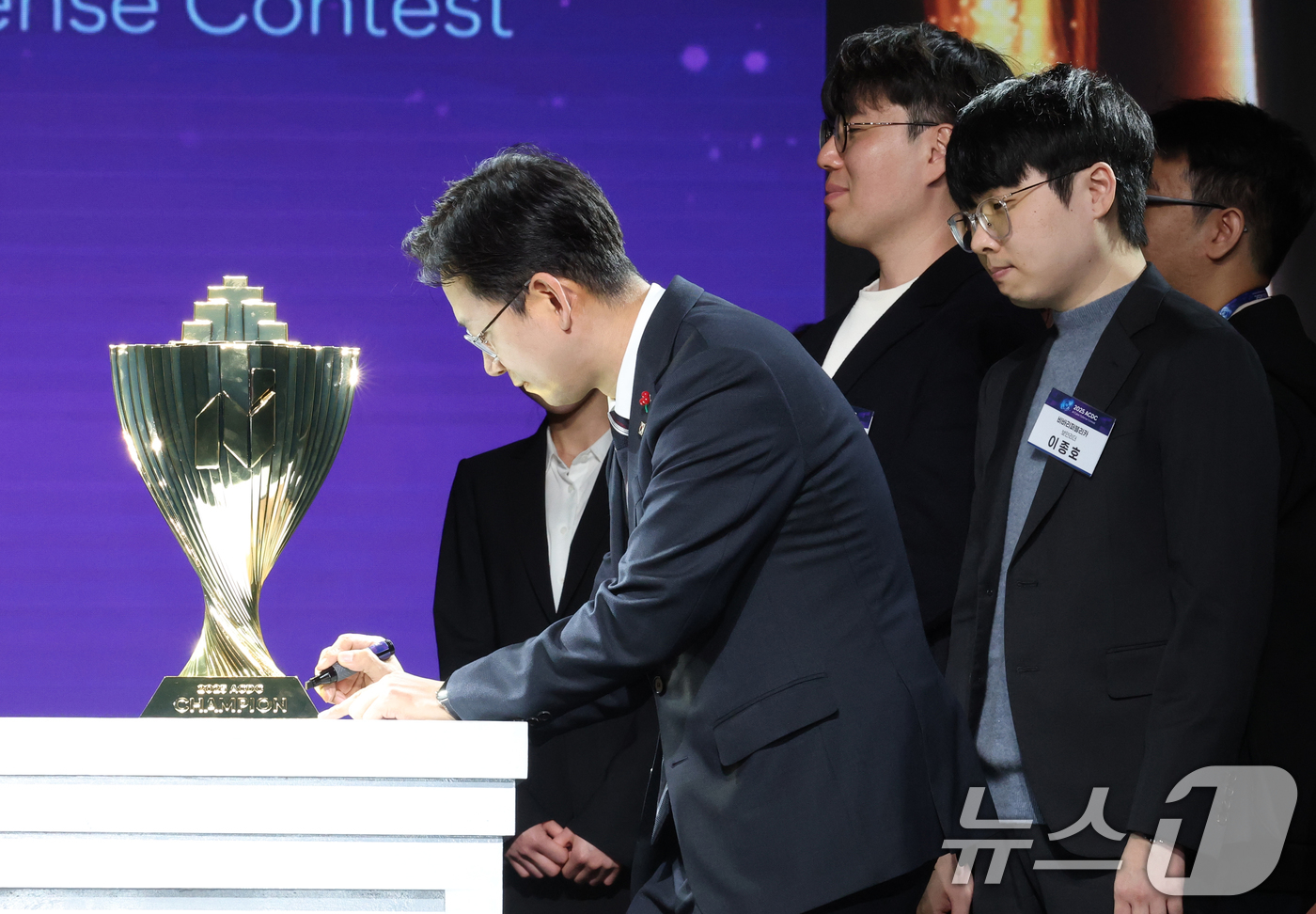 (서울=뉴스1) 김영운 기자 = 배경훈 부총리 겸 과학기술정보통신부 장관이 1일 서울 강남구 코엑스에서 열린 2025 AI 해킹방어 대회(ACDC) 개회식에서 우승 트로피에 서명을 …