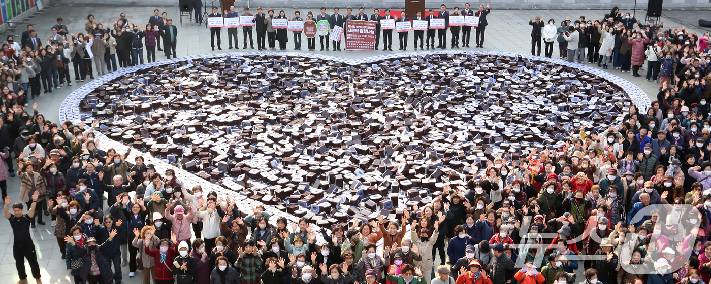 (부산=뉴스1) 윤일지 기자 = 1일 오후 부산 부산진구 송상현광장에서 열린 '제16회 1만세대 사랑의 김장 나눔 발대식'에서 자원봉사자 등 참석자들이 김치통으로 하트 모양을 만들 …