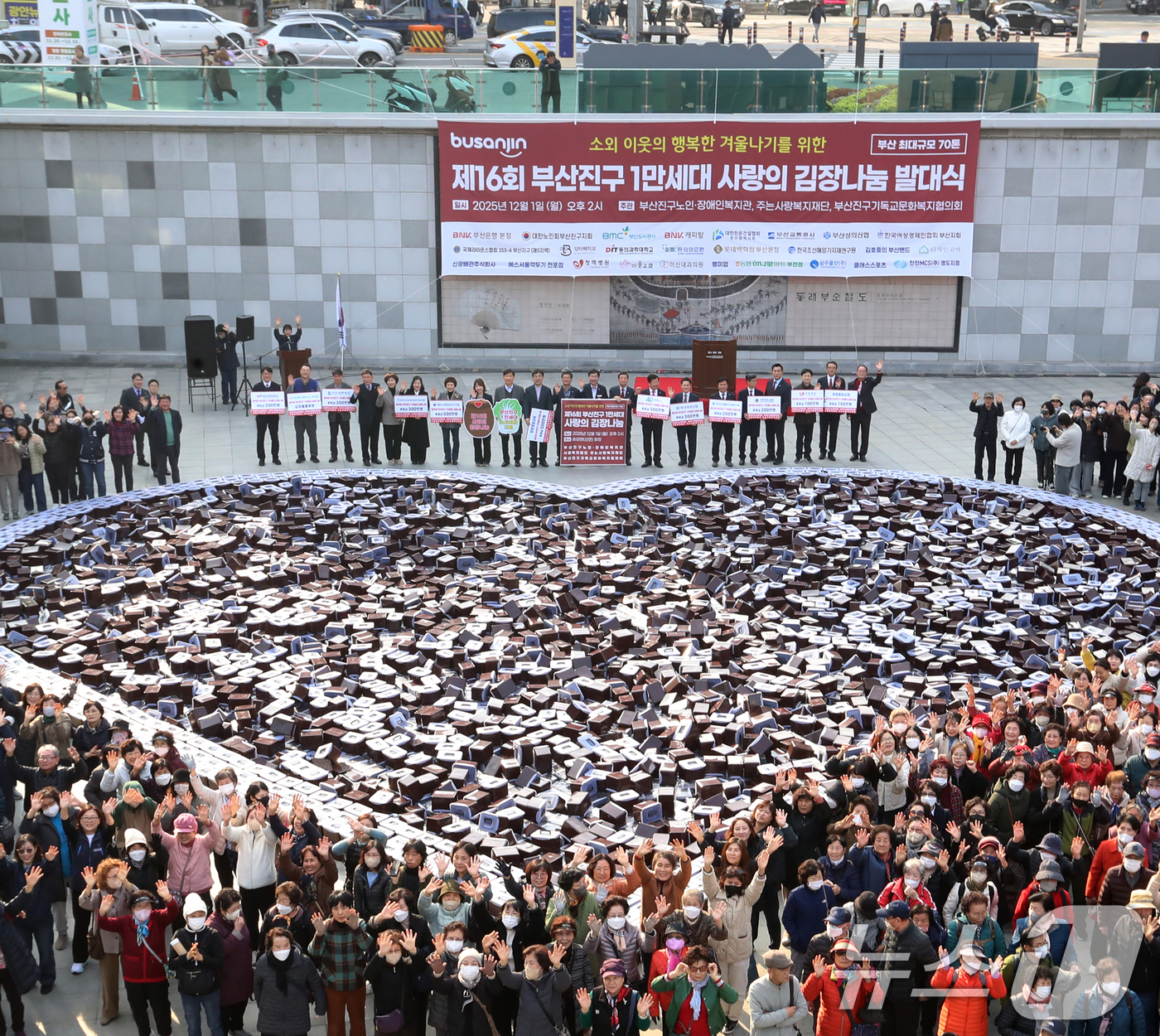 (부산=뉴스1) 윤일지 기자 = 1일 오후 부산 부산진구 송상현광장에서 열린 '제16회 1만세대 사랑의 김장 나눔 발대식'에서 자원봉사자 등 참석자들이 김치통으로 하트 모양을 만들 …