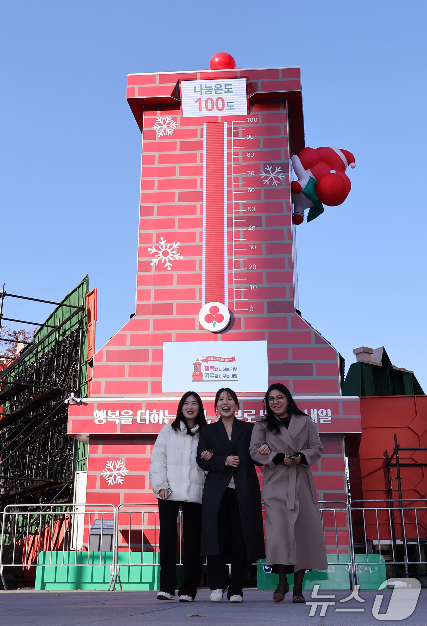 (서울=뉴스1) 박지혜 기자 = 1일 오후 서울 광화문광장에 점등된 사랑의 온도탑 앞으로 시민들이 지나가고 있다. 2025.12.1/뉴스1