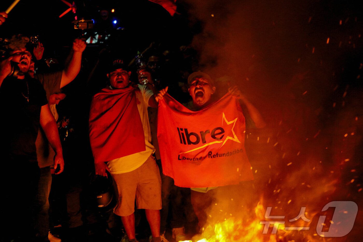 본문 이미지 - 시오라마 카스트로 온두라스 대통령이 11월 30일 대선의 개표 과정에서 기술적 오류, 사기 주장,도널드 트럼프 미국 대통령의 &#34;선거 쿠데타&#34;를 비난한 후, 온두라스 테구시갈파의 국가선거위원회&#40;CNE&#41; 시설 밖에서 집권당 리브레당 지지자들이 시위를 벌이고 있다. ⓒ 로이터=뉴스1 ⓒ News1 이정환 기자