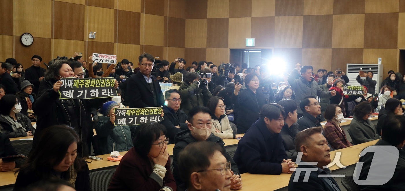 (제주=뉴스1) 고동명 기자 = 10일 오전 제주4·3평화교육센터에서 열린 제주평화인권헌장 선포식에서 일부 보수·종교단체 등이 헌장 폐기를 요구하는 손팻말을 들어 항의하고 있다. …