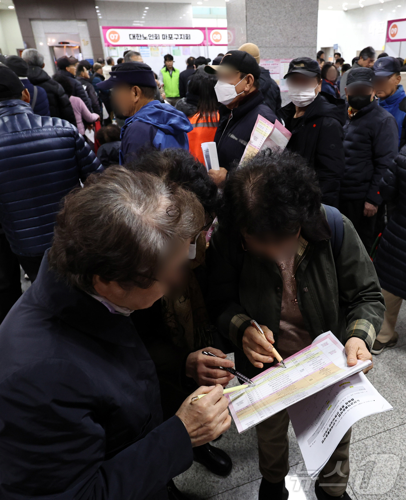 (서울=뉴스1) 구윤성 기자 = 10일 오후 서울 마포구청에서 열린 노인일자리 박람회에서 어르신들이 참가업체 모집요강을 살펴보고 있다. 2025.12.10/뉴스1