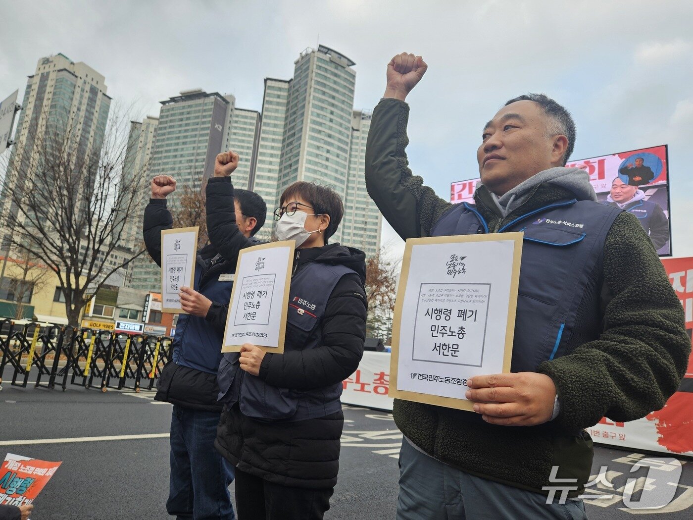 본문 이미지 - 10일 오후 서울 용산구 삼각지역 인근에서 진행된 전국민주노동조합총연맹 결의대회에서 참가자 3명이 대통령실에 전달할 '시행령 폐기 민주노총 서한문'을 들어보이고 있다. 2025.12.10/뉴스1 ⓒ News1 유채연 기자