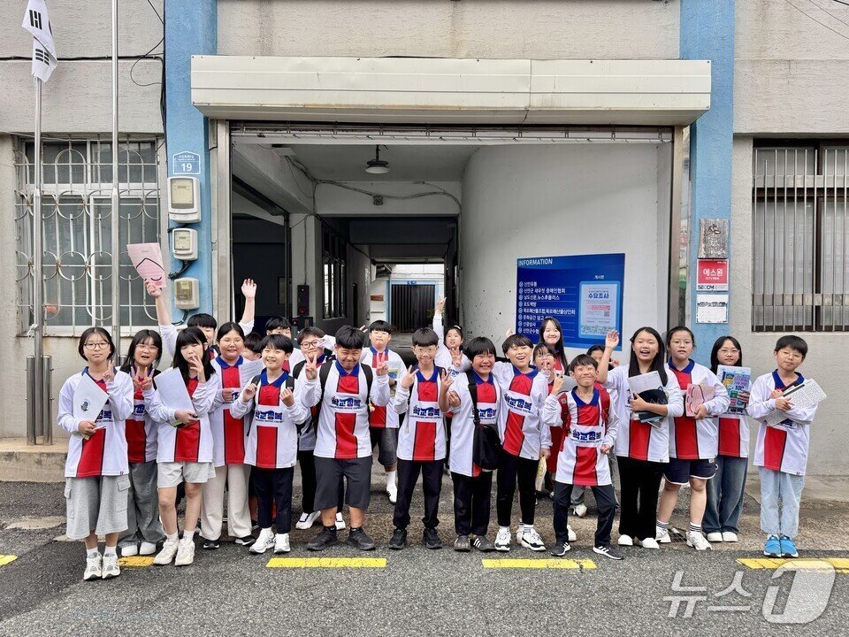 본문 이미지 - 학생들이 영화 &#39;학교정복&#39; 홍보 티셔츠를 입고 현장체험 인증 사진에 포즈를 취하고 있다.&#40;전남도교육청 제공, 재판매 및 DB 금지&#41;/뉴스1 