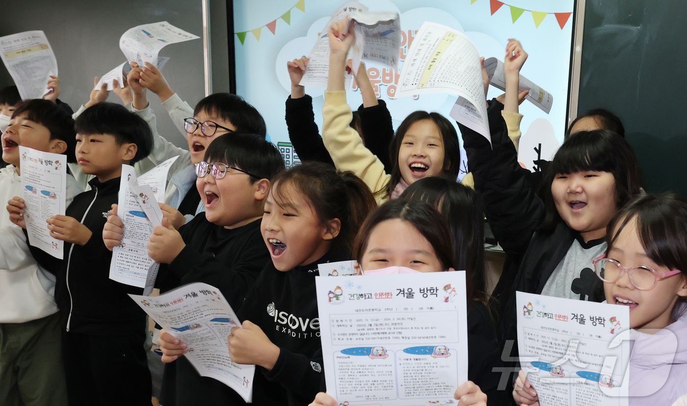 (대전=뉴스1) 김기태 기자 = 대전지역 학교가 순차적으로 방학에 돌입한 가운데 11일 대전 서구 도마초등학교에서 방학을 맞은 3학년 학생들이 방학 생활지도 안내문을 들고 환호하고 …